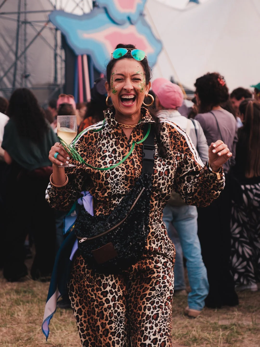 Festivaliere en combinaison leopard avec glitter vert riant un verre a la main, We Love Green