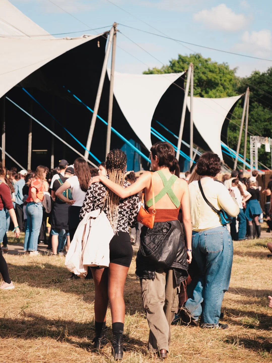 Deux festivalières marchant bras dessus bras dessous vers une scene sous tente, We Love Green