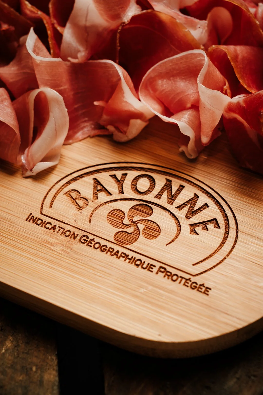 Sceau officiel de l'IGP Bayonne gravé sur bois sous la charcuterie