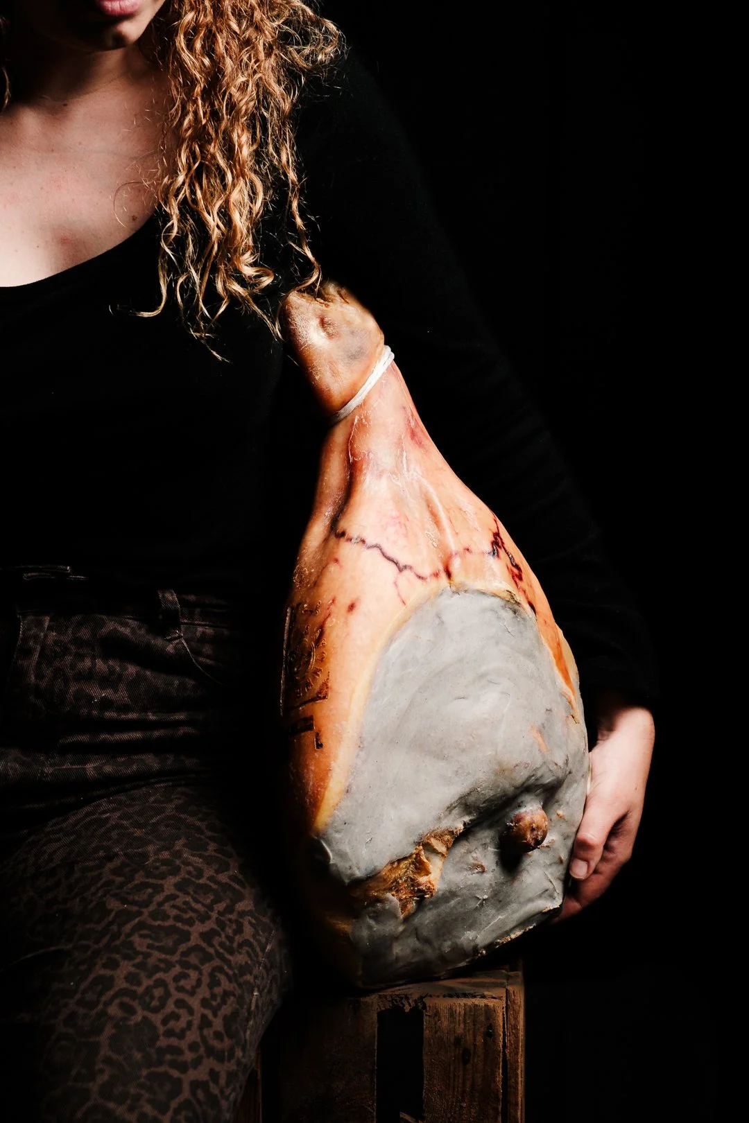 Jambon de Bayonne entier porté sur fond noir, visuel brut pour de la charcuterie terroir