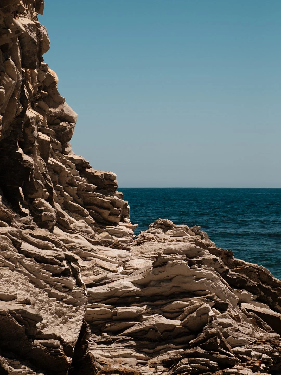 Falaises de roche brute plongeant dans l'océan sur la côte basque