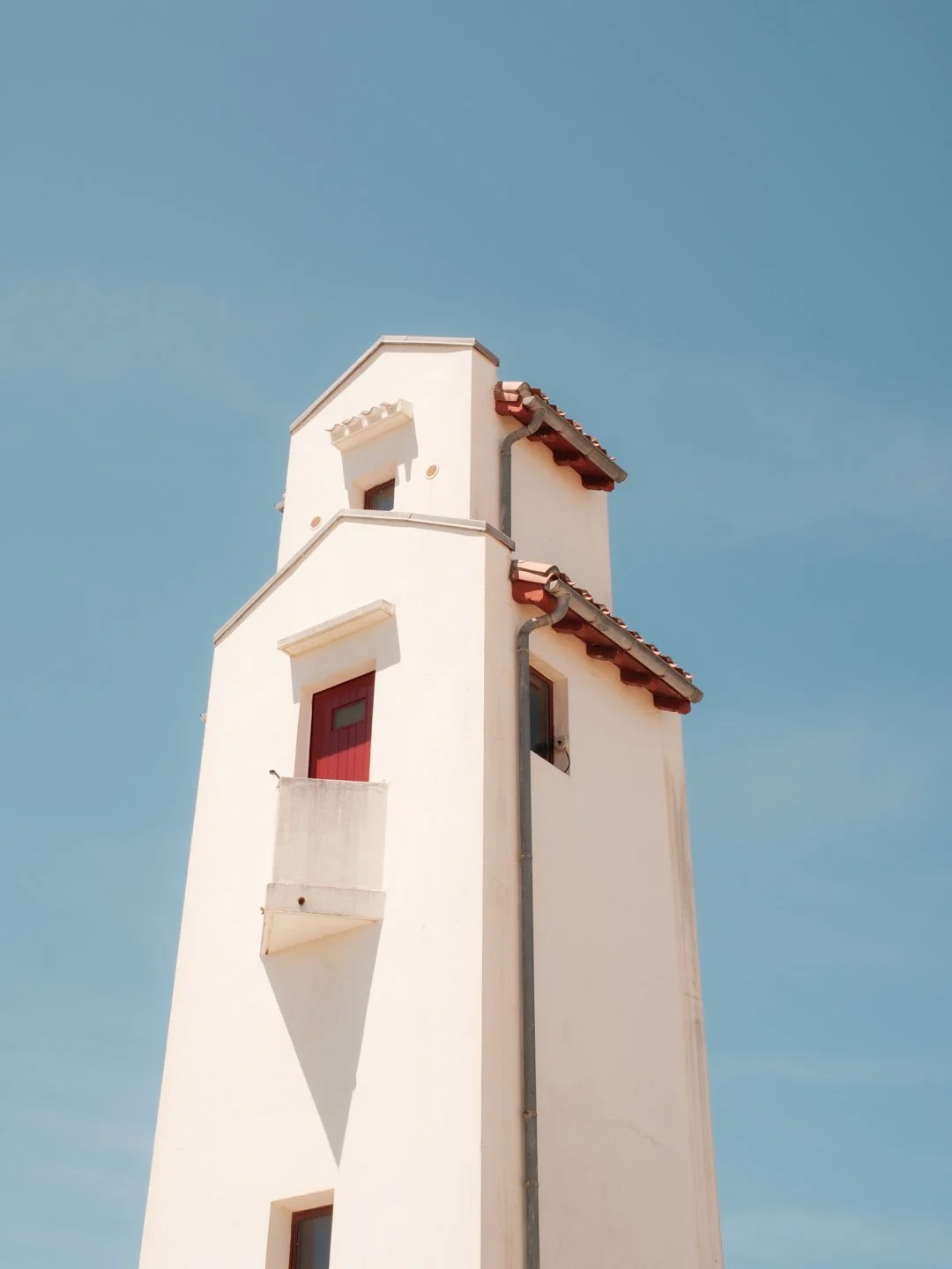 Le phare de Saint-Jean-de-Luz sous un grand ciel bleu, photographie architecturale minimaliste