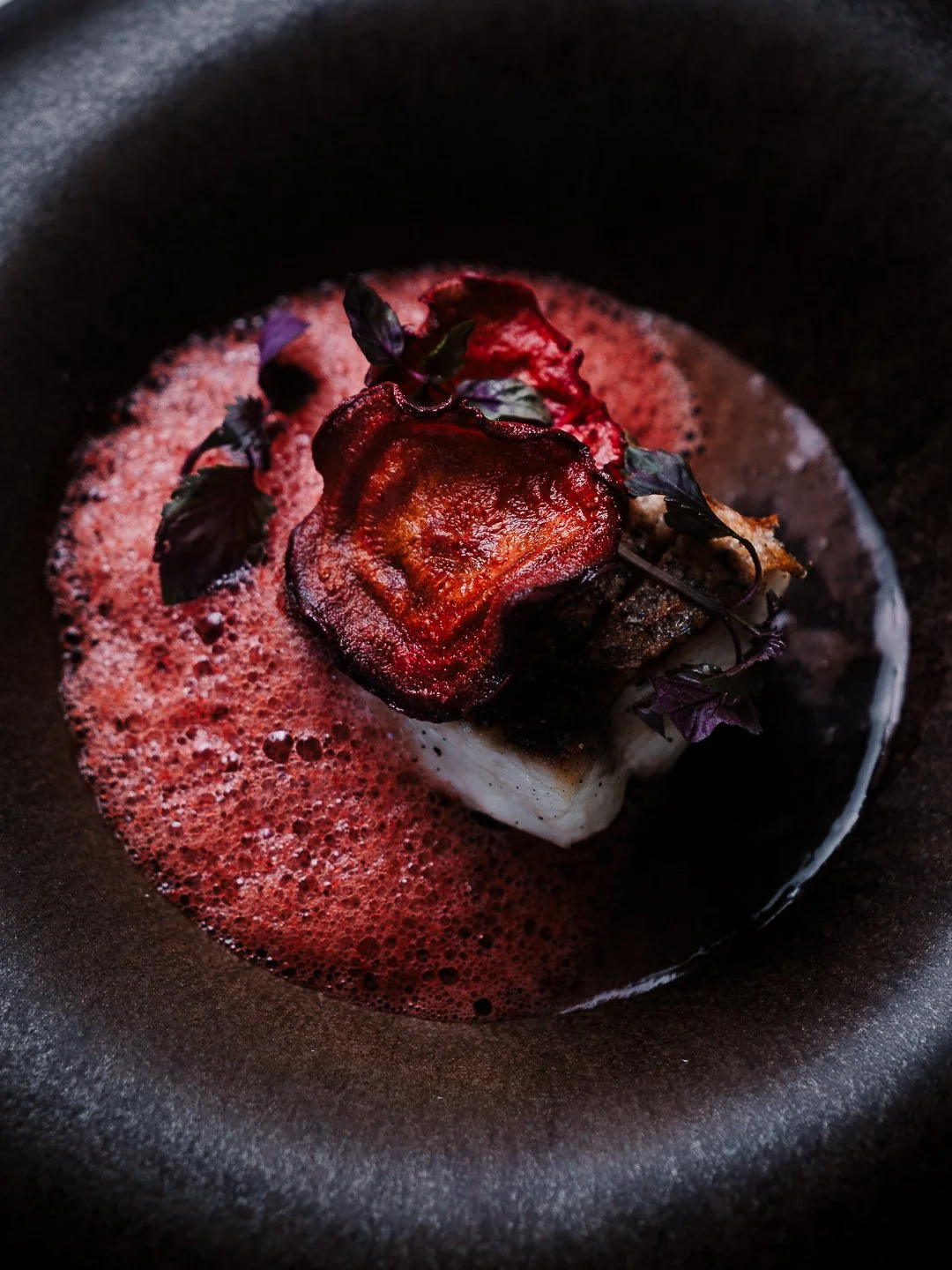Assiette gastronomique noire avec poisson, betterave et emulsion rouge, restaurant l'Esberit.