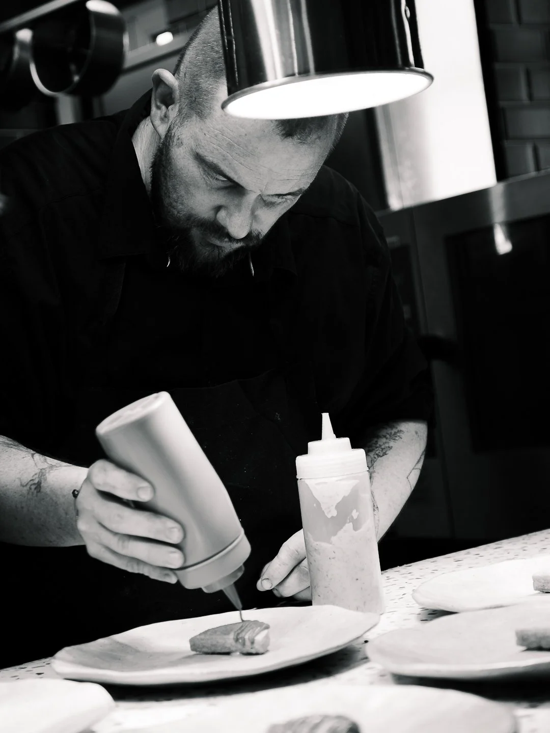 Chef Nicolas Lormeau en noir et blanc penche sur le dressage, l'Esberit Pau.