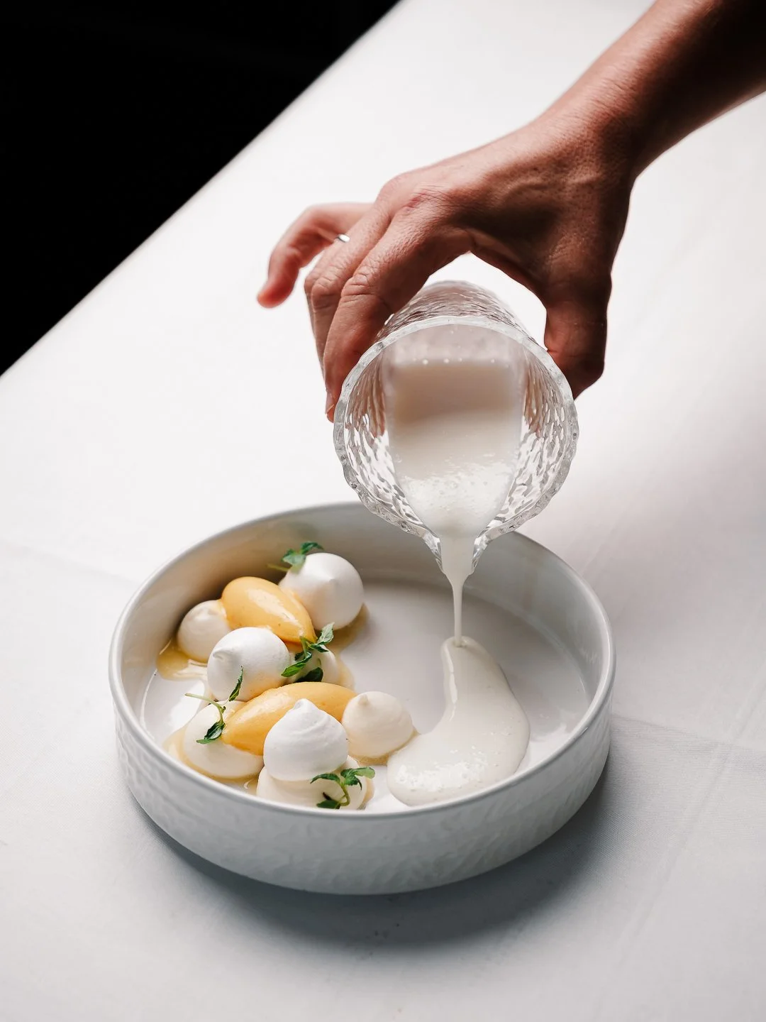 Service d'emulsion laiteuse dans une assiette dessert, restaurant gastronomique l'Esberit a Pau.