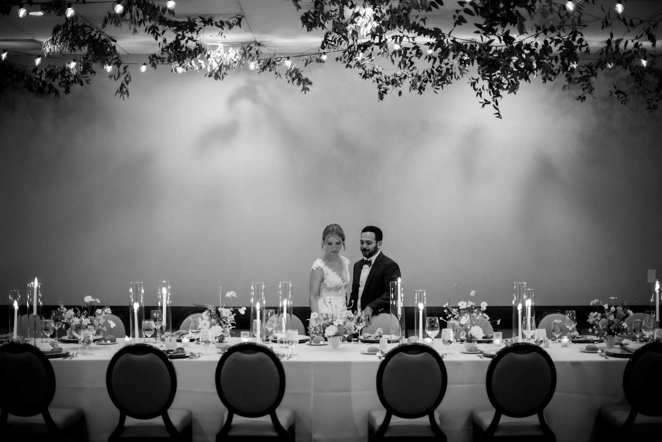 Black and white photo of bride and groom seeing their wedding reception decor for the first time