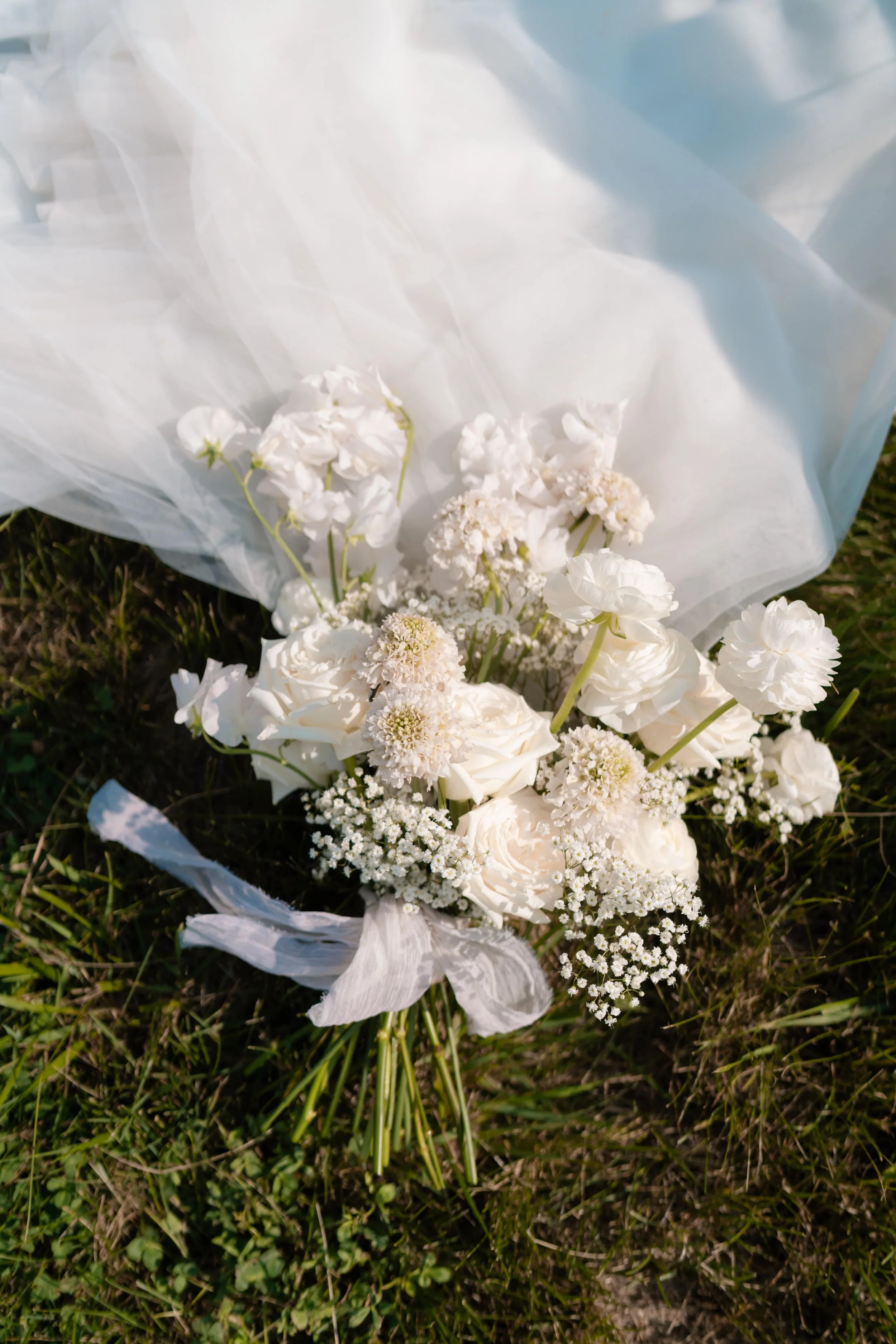 White modern bridal bouquet laid in the grass