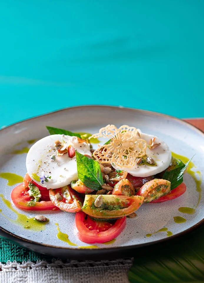 A bright and fresh Caprese salad with ripe tomatoes, basil, and mozzarella, served at Koa Dining, Tolani Koh Samui.
