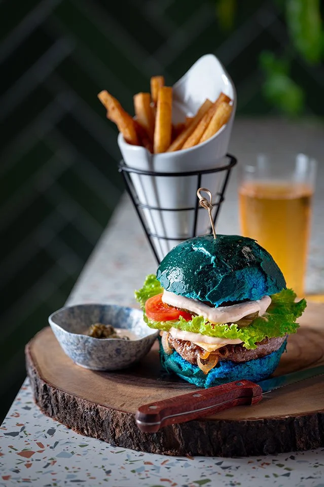 A unique vegan burger with vibrant blue buns, served at Koa Dining, Tolani Koh Samui.
