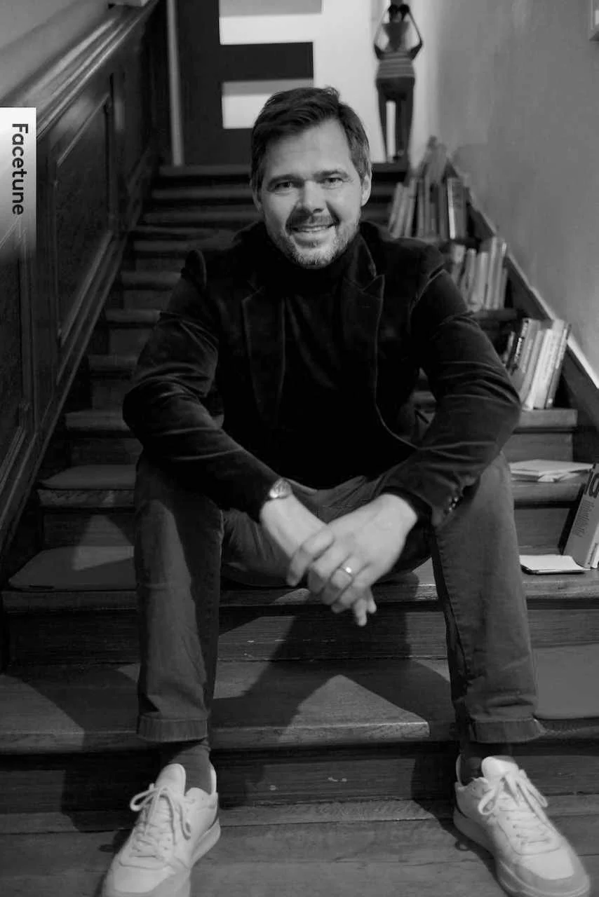 Ein Mann sitzt auf einer Treppe, die Bibliothek im Hintergrund sichtbar, schwarz-weiß Fotografie.