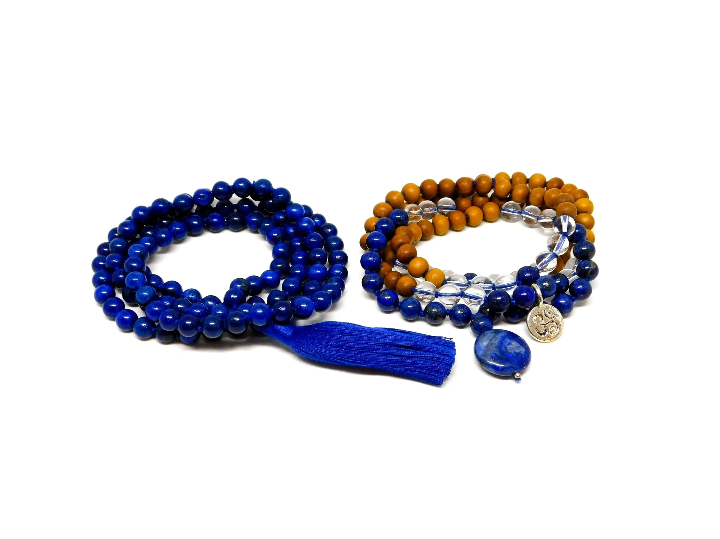 Three strands of prayer beads, two large with blue beads and one mixed with wooden, blue, clear, and silver beads, including a blue tassel and charms.