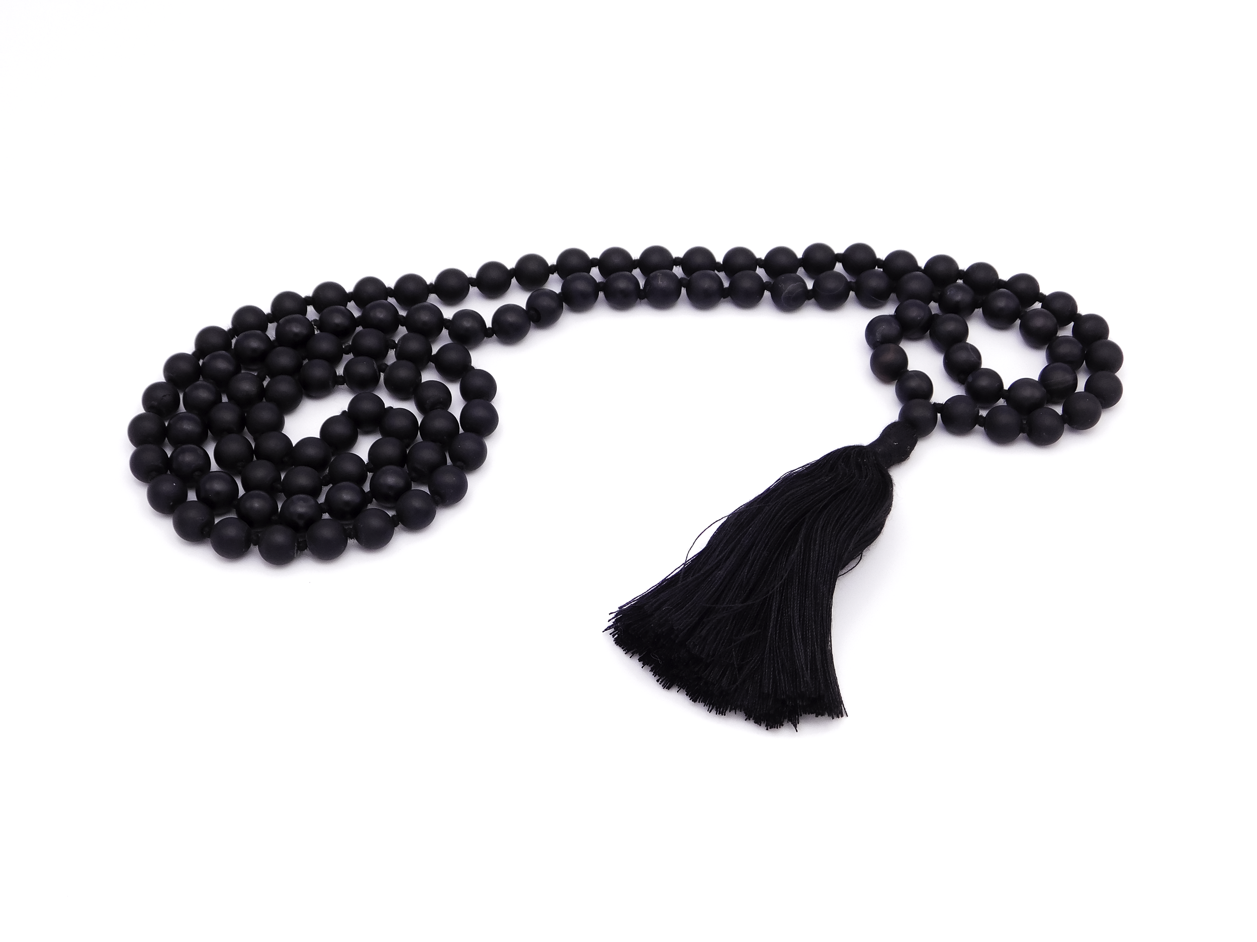 Black prayer beads with a tassel on a white background.