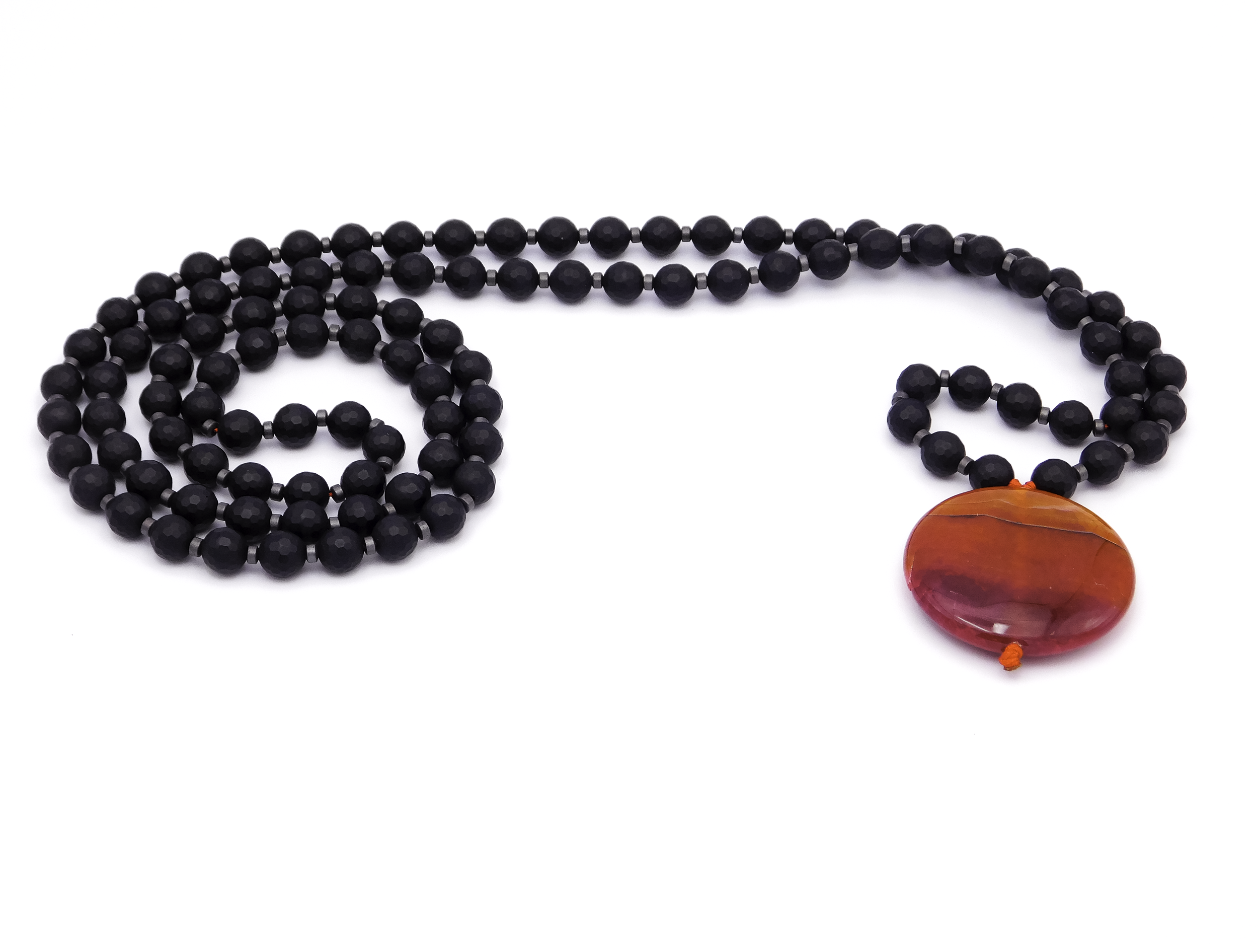 Beaded necklace with black beads and a large oval orange-brown pendant on a white background.