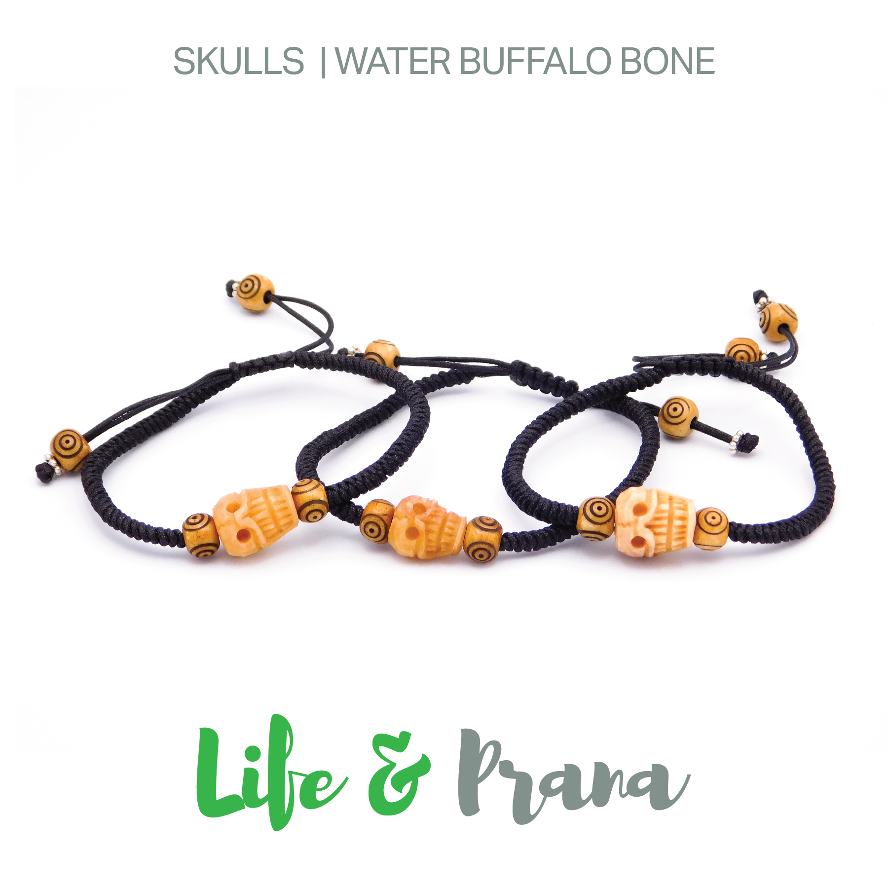 Three black string bracelets with orange skull and round bead decorations, arranged in a row on a white background, with the text 'Skulls | Water Buffalo Bone' at the top and 'Life & Prana' at the bottom.