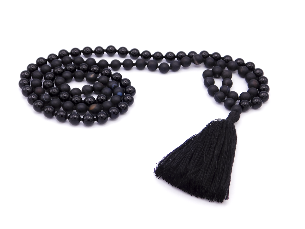 A black beaded rosary with a black tassel on a white background.