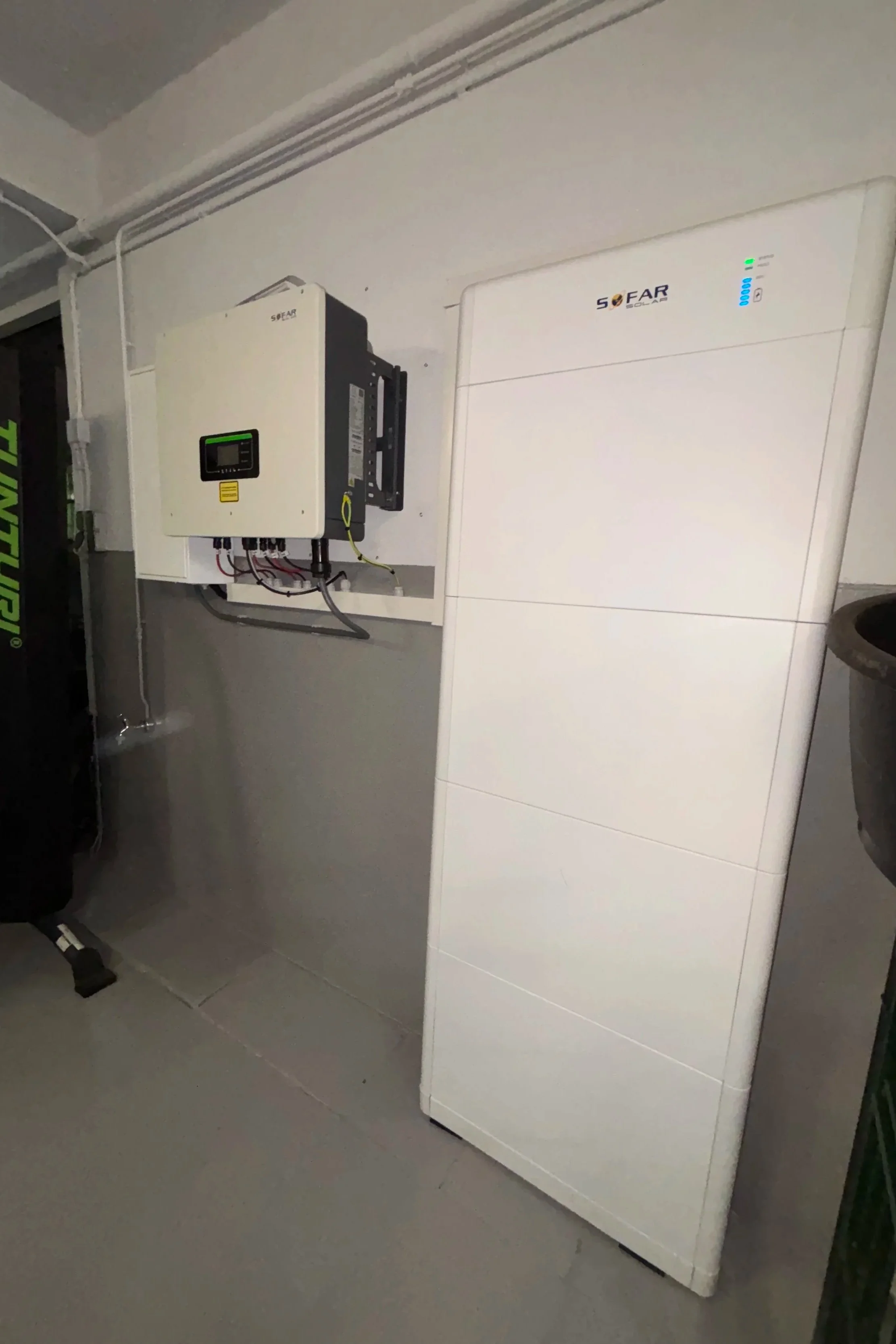 Een elektrische auto oplader en een batterijopslagkast in een garage.