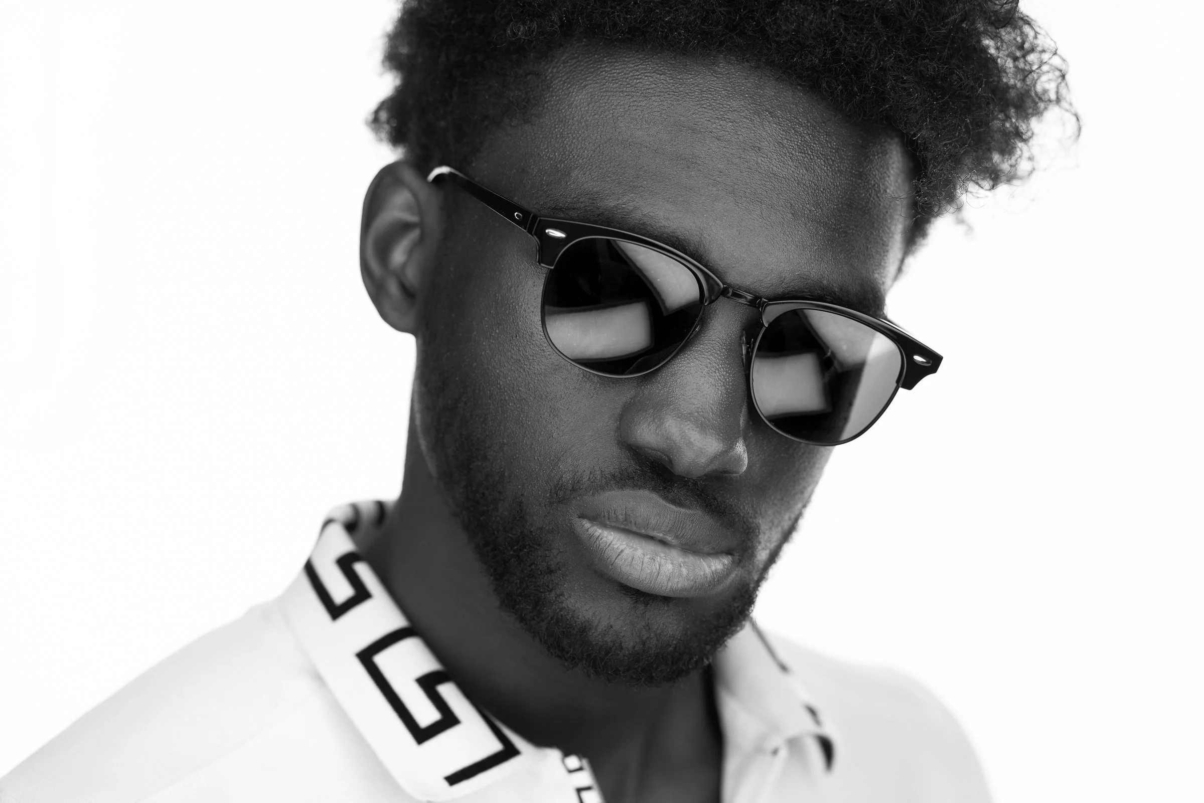 Headshot of a man wearing glasses and a white outfit