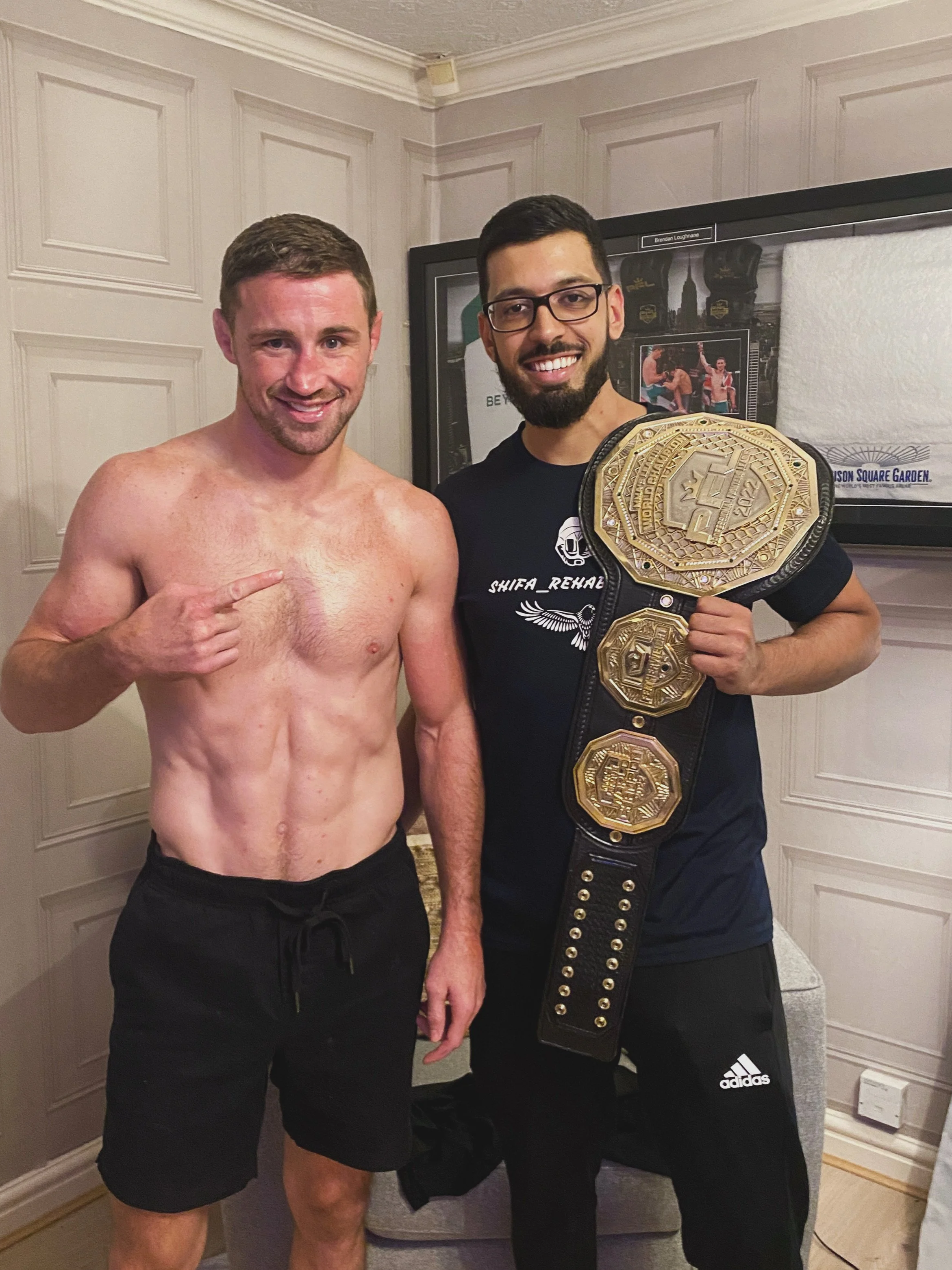 Shifa rehabilitation owner Bilal posing for a picture with professional mixed martial artist and Manchester native Brendan Loughnane, the 2022 PFL Featherweight Champion of the Professional Fighters League.