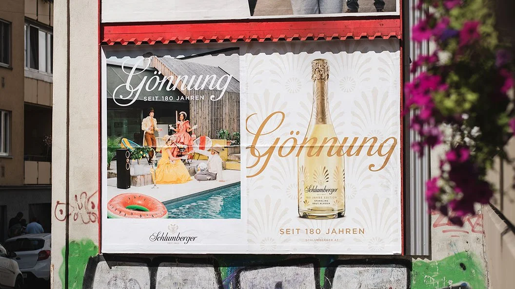 Werbung für Schlumberger Sekt, feiert 180 Jahre, mit einem Bild von Menschen beim Feiern im Garten und einem Flaschenbild von Sekt.