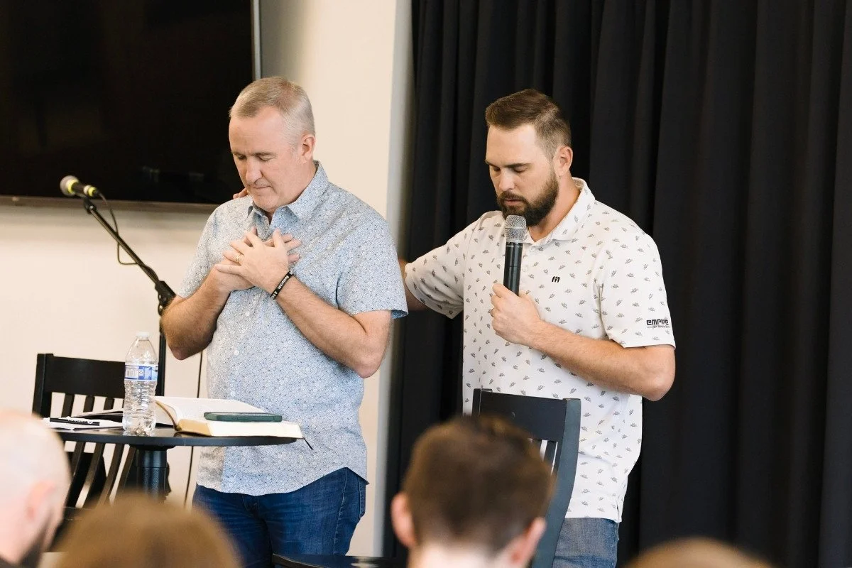Two leaders of Antioch Discipleship School praying for the class of students at a Sunday night class.