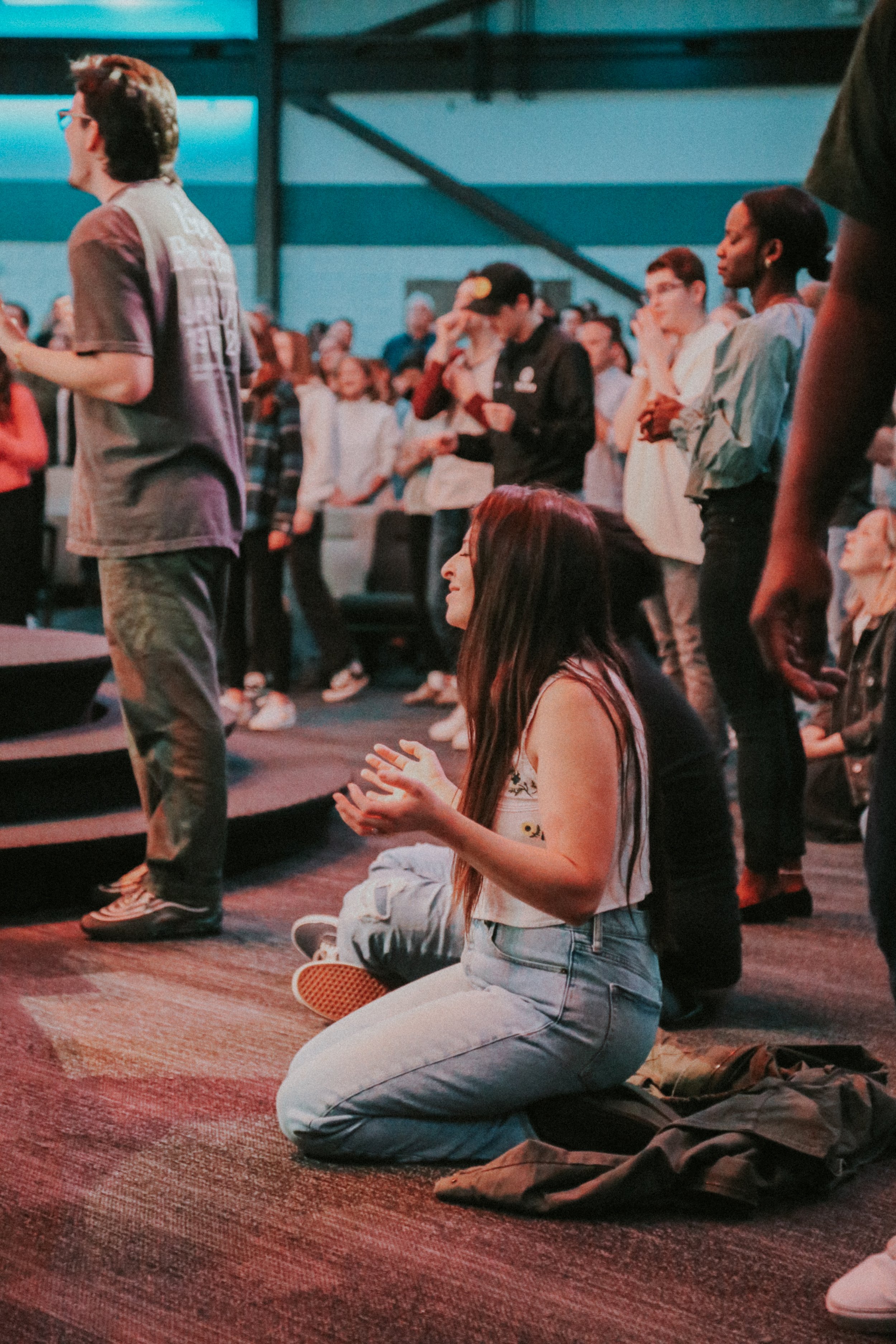 Woman kneeling during Antioch Community Church's Sunday worship service in Chandler
