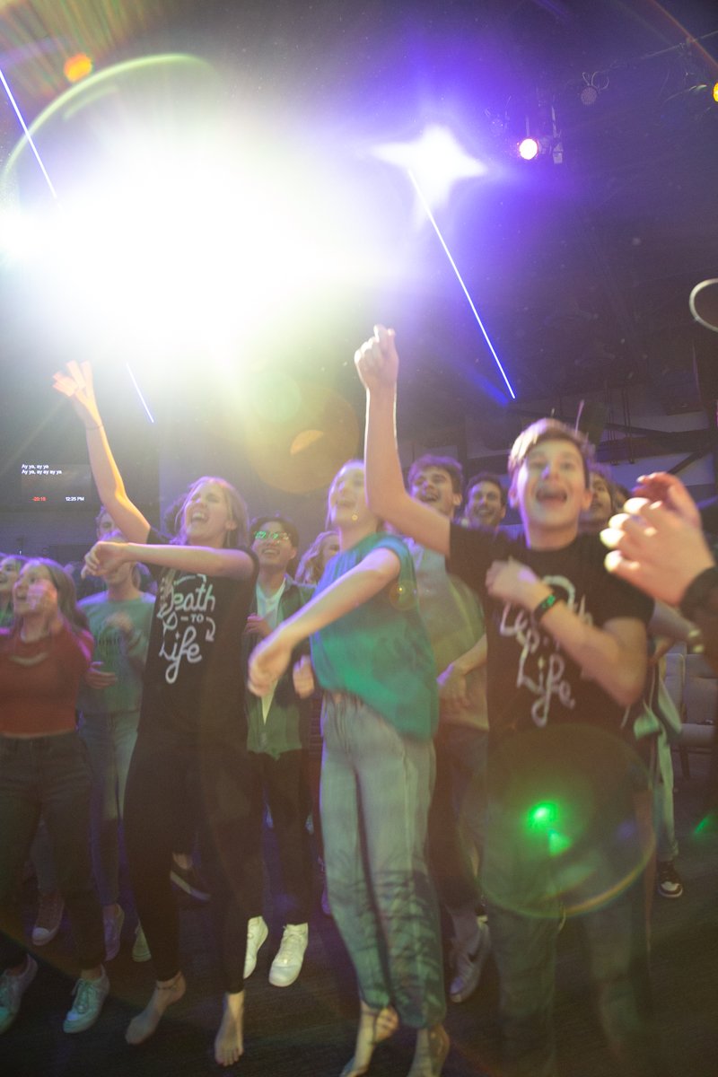 Middle school students at Antioch Community Church dancing during worship.