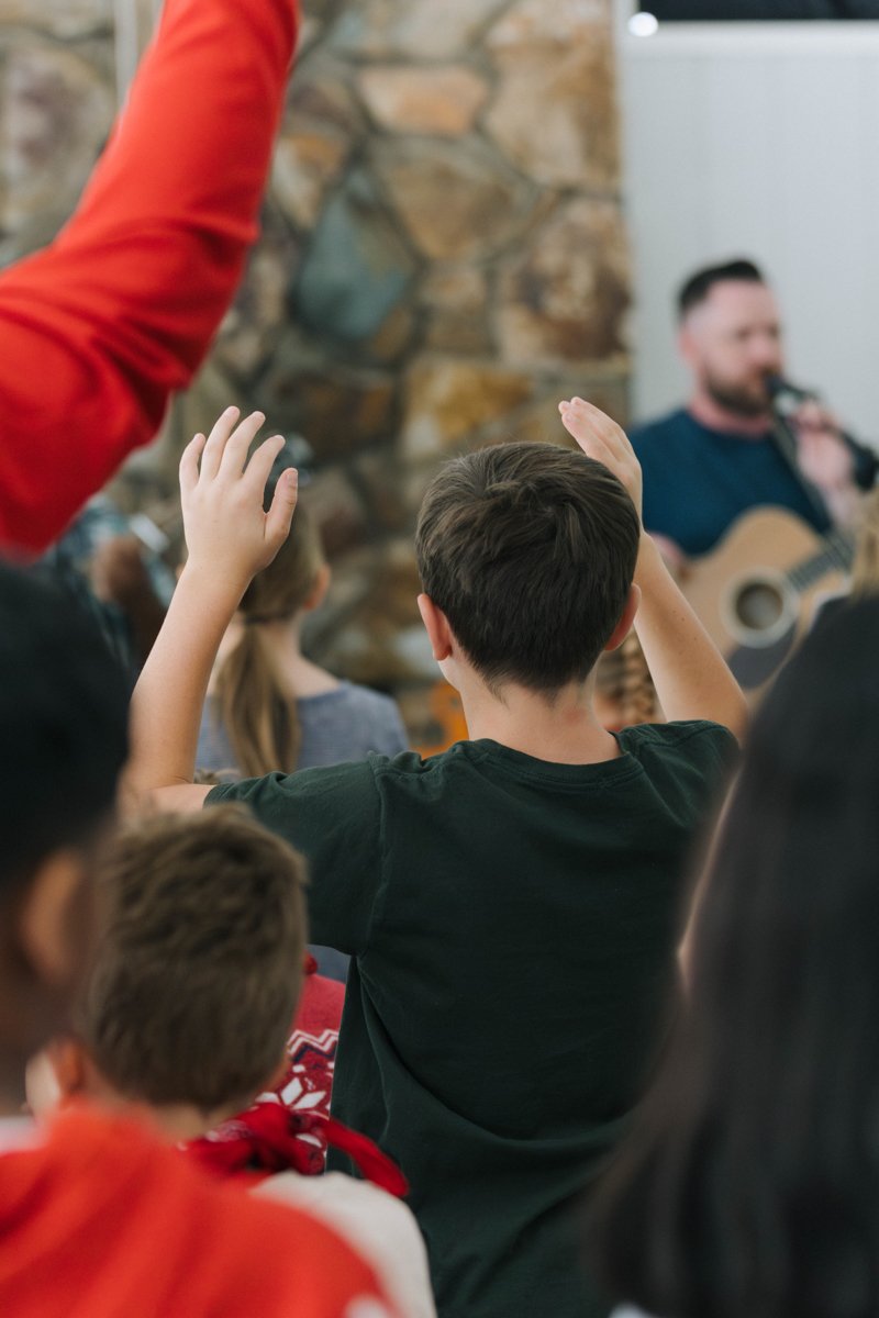 A  boy worshipping from Antioch community church at kids camp