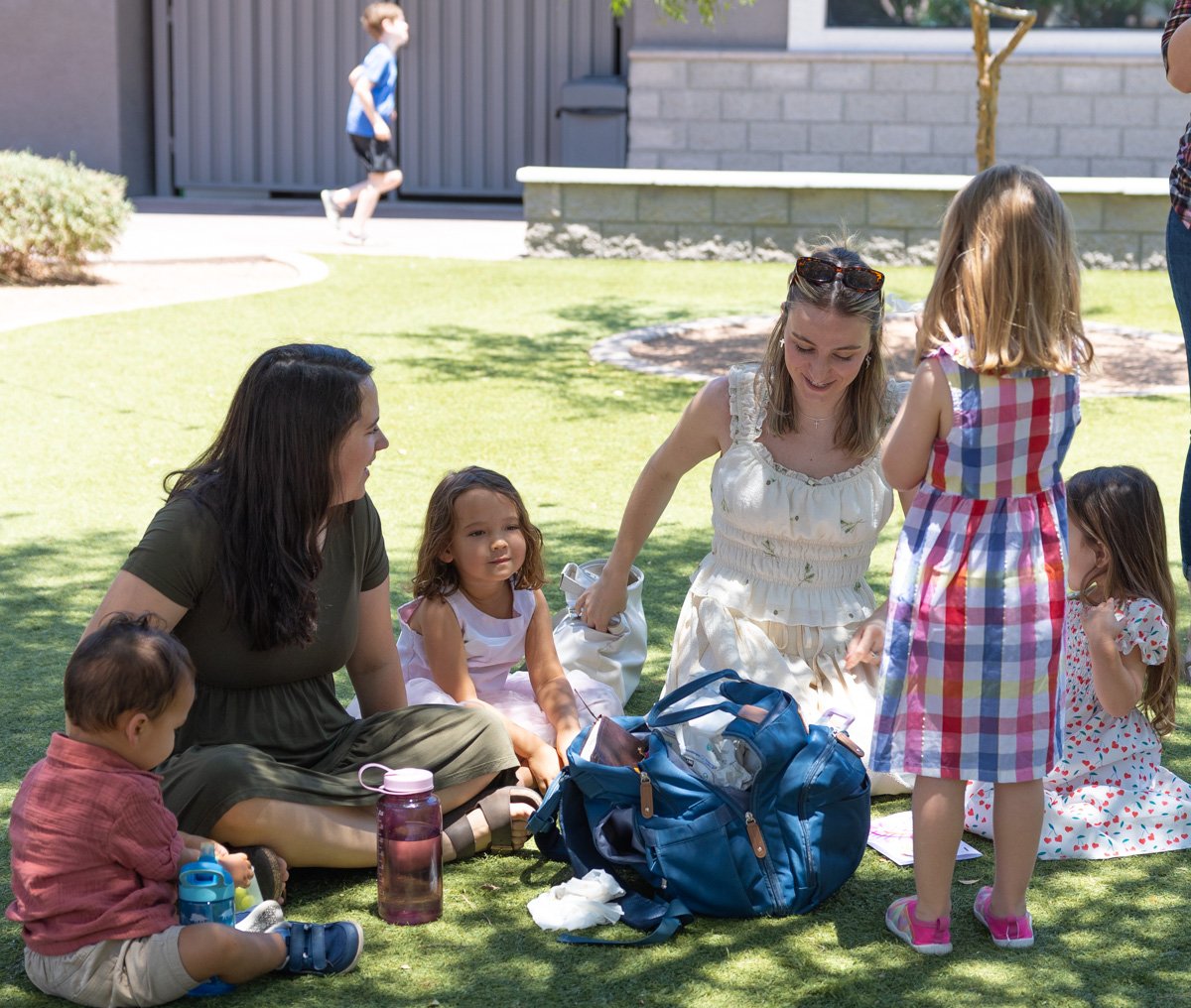 A families life group gathers on the grass after a Sunday worship service at Antioch Community Church in Chandler