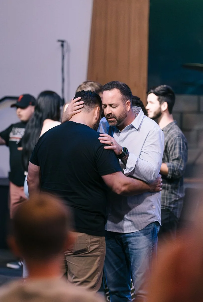 Two men praying together during a Sunday worship service at Antioch Community Church in Chandler Dobson campus