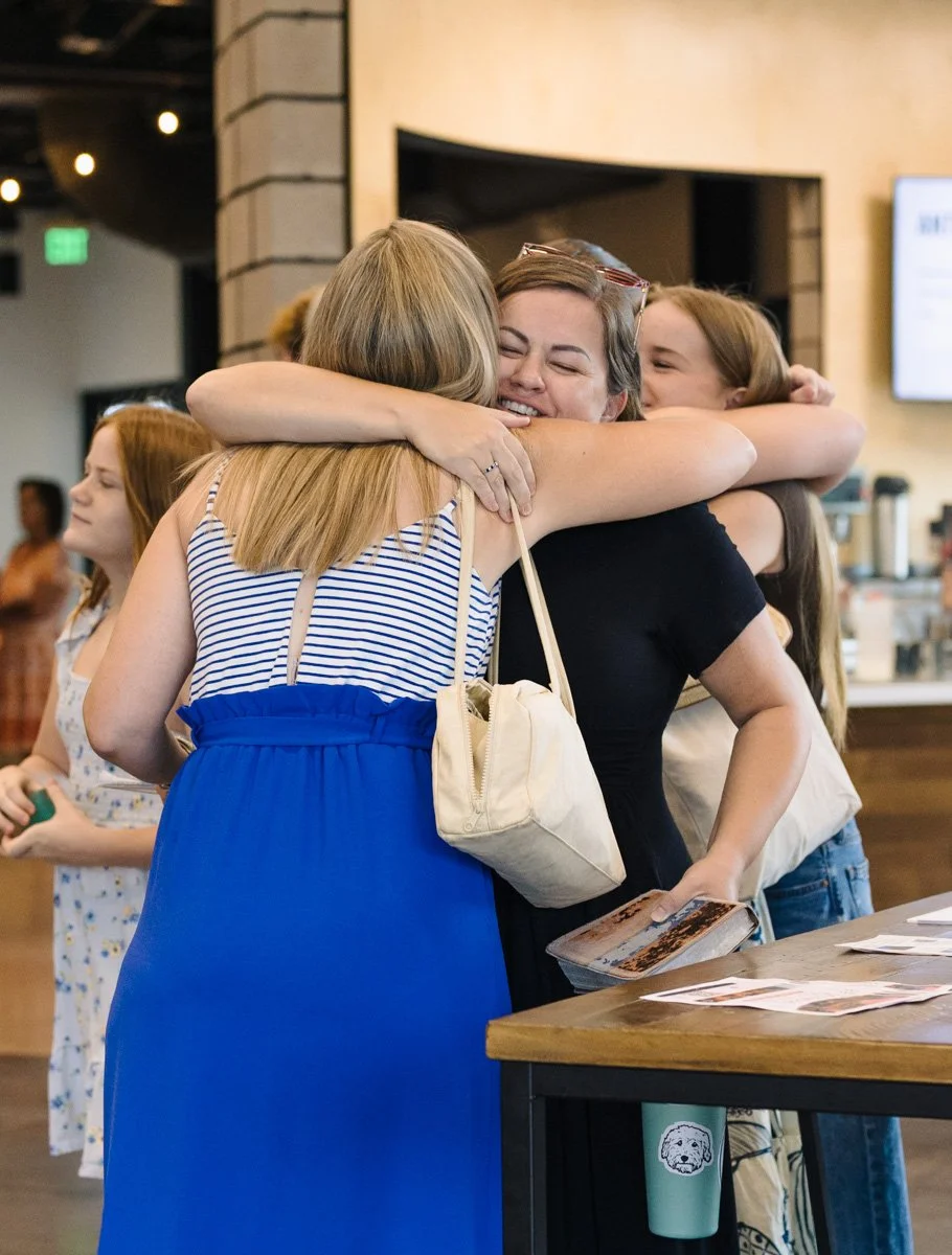 Two women hugging before a sunday service at Antioch Community Church in Chandler Dobson Campus