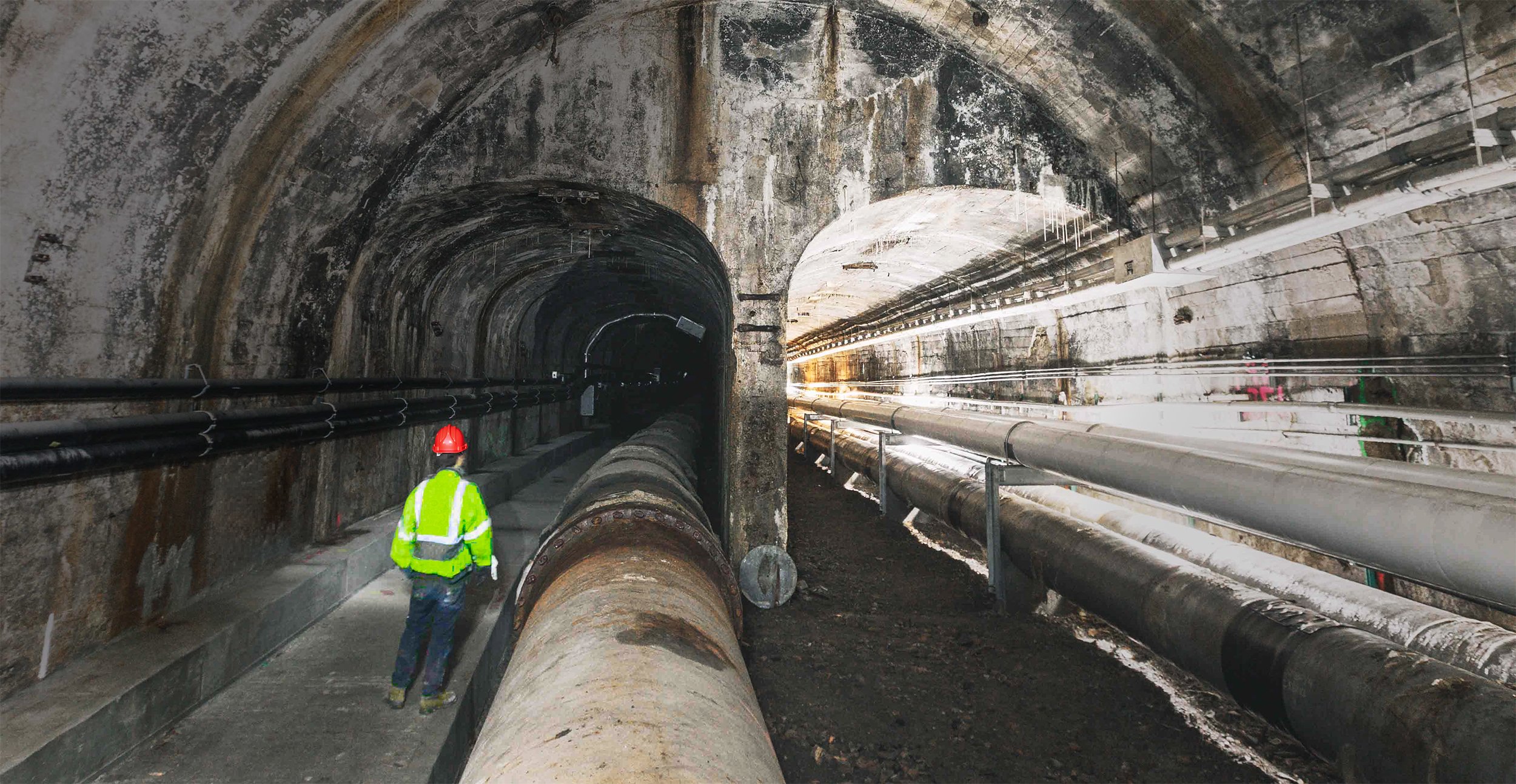 Worker inspecting the historic 1871 LaSalle Street trolley tunnel beneath downtown Chicago.