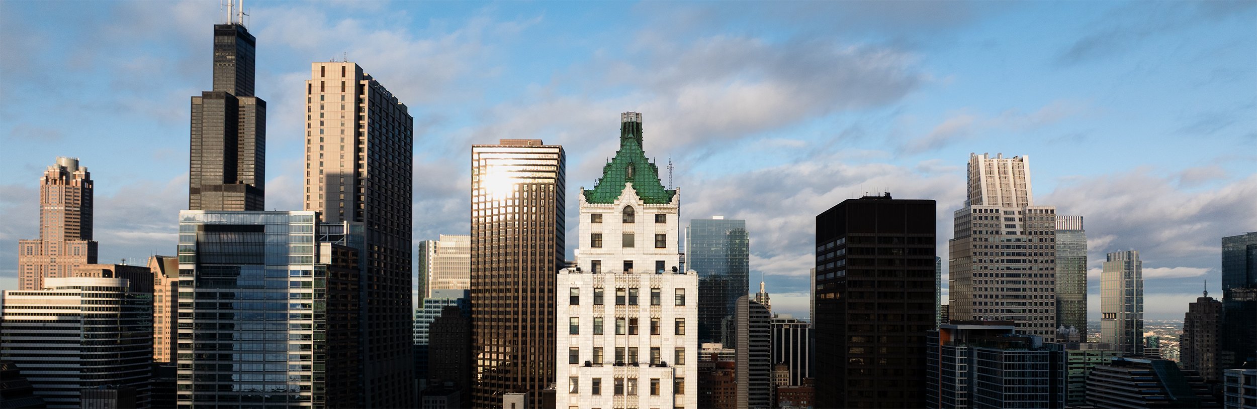 Pittsfield Building rising above downtown Chicago, with its historic white terra cotta facade and copper roof visible against the city skyline.