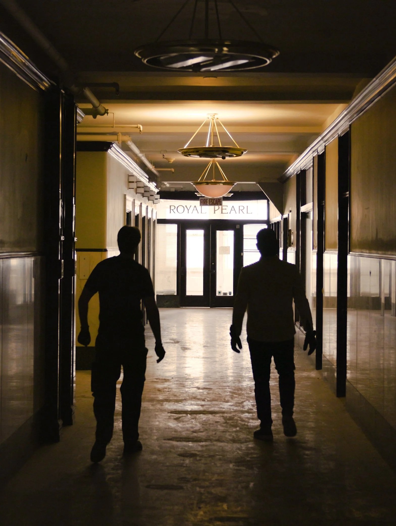Elliott Pepich and Tom Liravongsa walking through a historic corridor inside the Pittsfield Building near the former Royal Pearl offices.