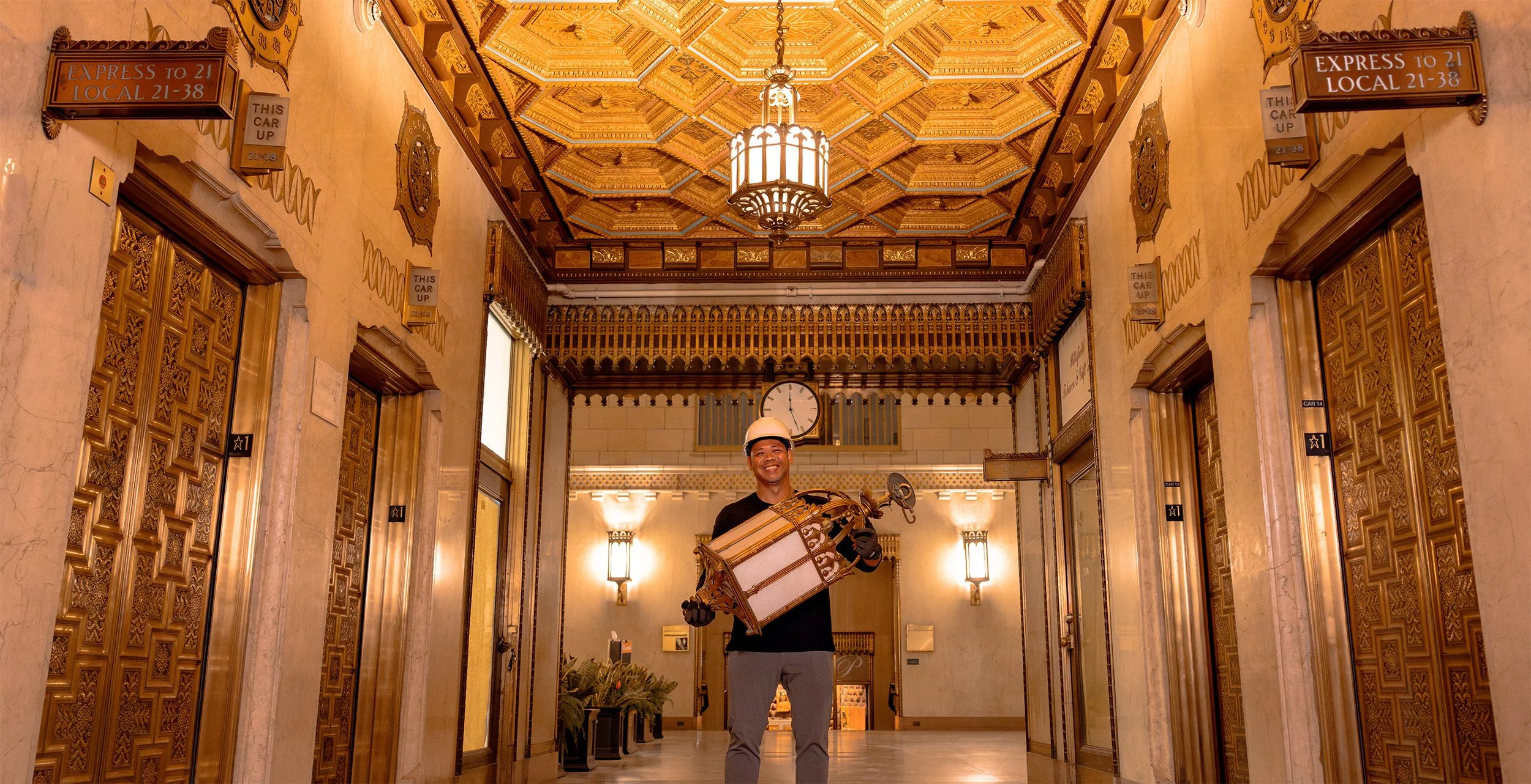 Skyscraper Guy standing in the historic Pittsfield Building lobby holding an original ornate 1927 light fixture discovered during restoration.