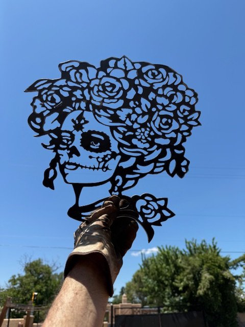 The Dia de Los Muertos Lady is 16 gauge metal she is 15x15 inches.