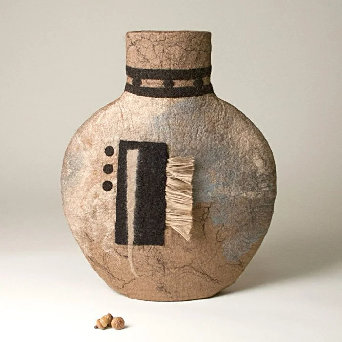 Textured pottery vase with geometric design and organic elements