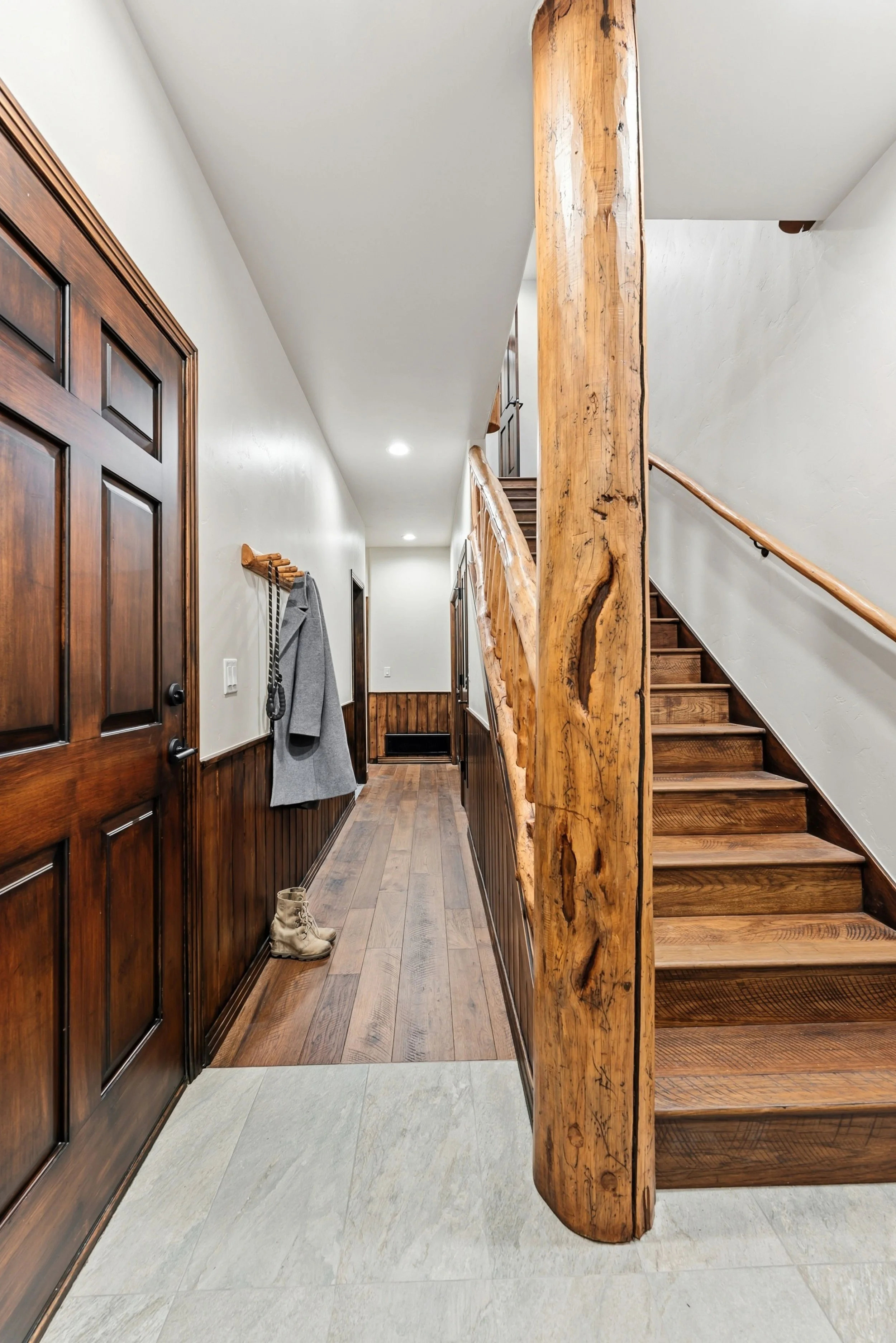 Entry hall and staircase with a log post in a Frisco, Colorado remodel designed by Elle Schwab of Elle J Design