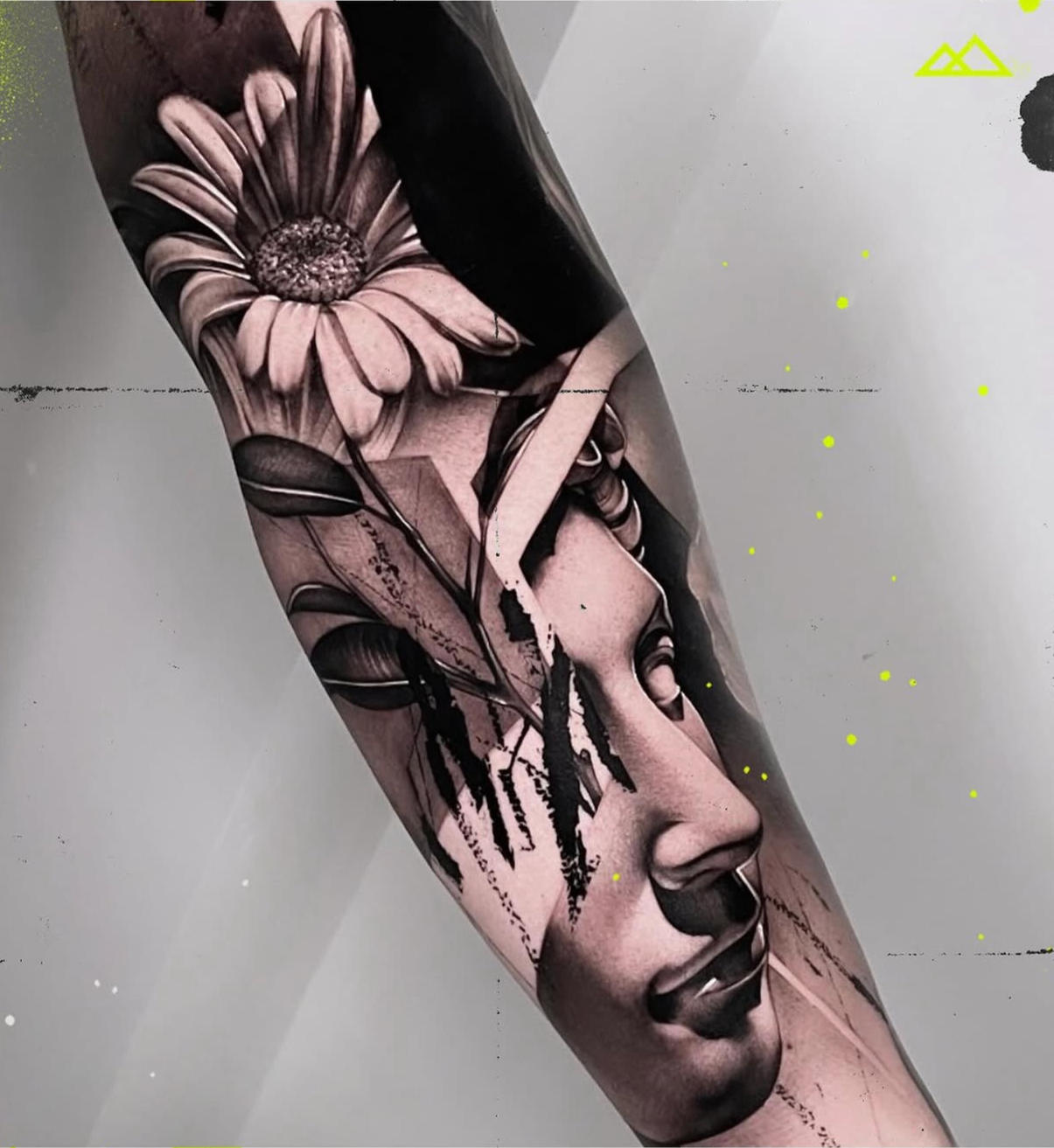 Black and gray tattoo of a woman's face with closed eyes, overlaid with abstract and graphic elements on a person's thigh.