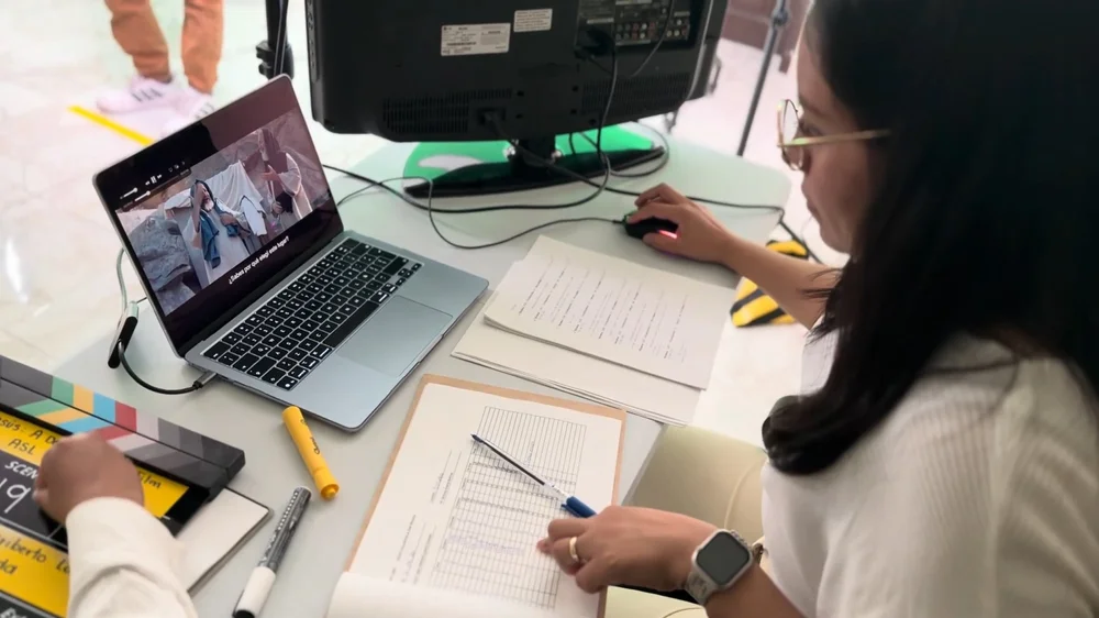 A translator working at a laptop with handwritten notes