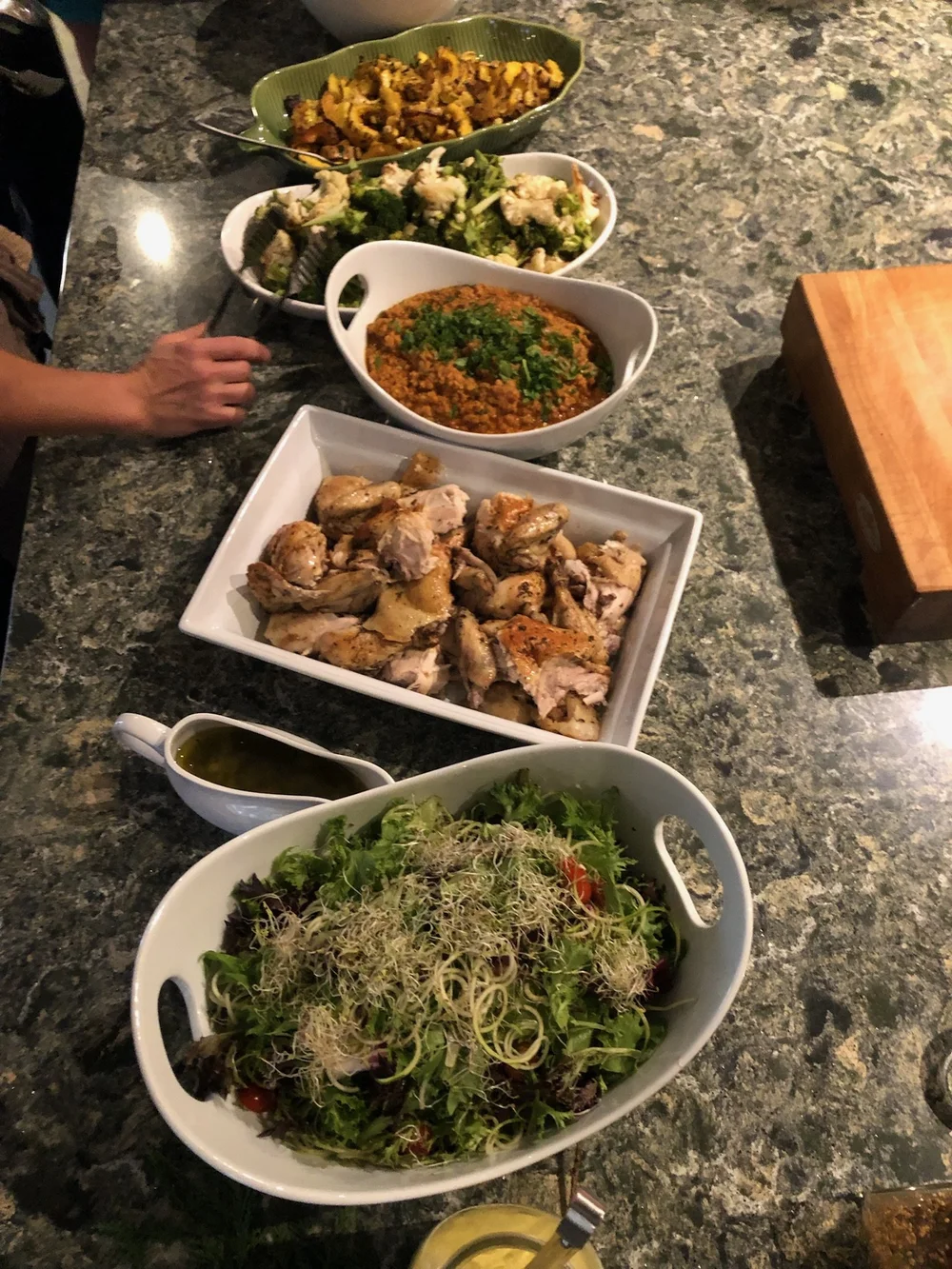 Family-style shared meal of salads and roasted dishes at the retreat