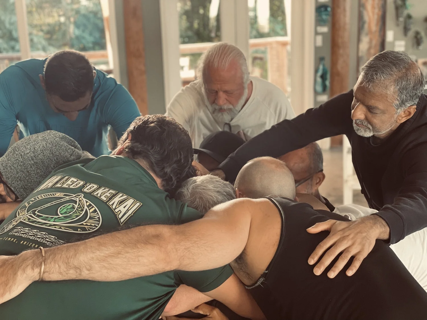 Men gathered in a close circle during the nightly men's group at a Himeros retreat