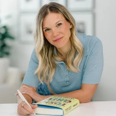 Smiling woman with blonde hair with a book