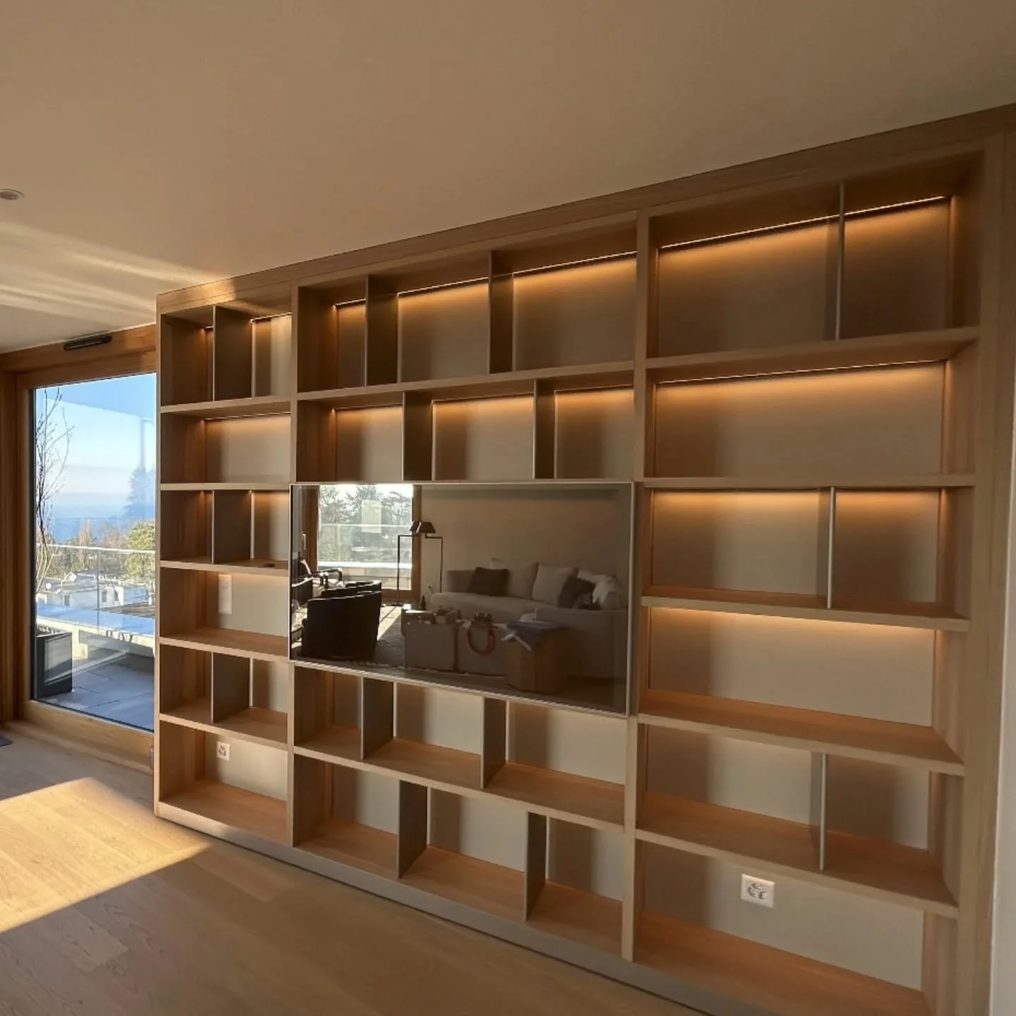 R&eacute;alisation d'une biblioth&egrave;que murale sur mesure.
Au milieu de la composition, nous avons int&eacute;gr&eacute; une porte coulissante vers le haut qui cache un bar.
Finitions: structure en bois ch&ecirc;ne clair, fond en laque mat, s&ea