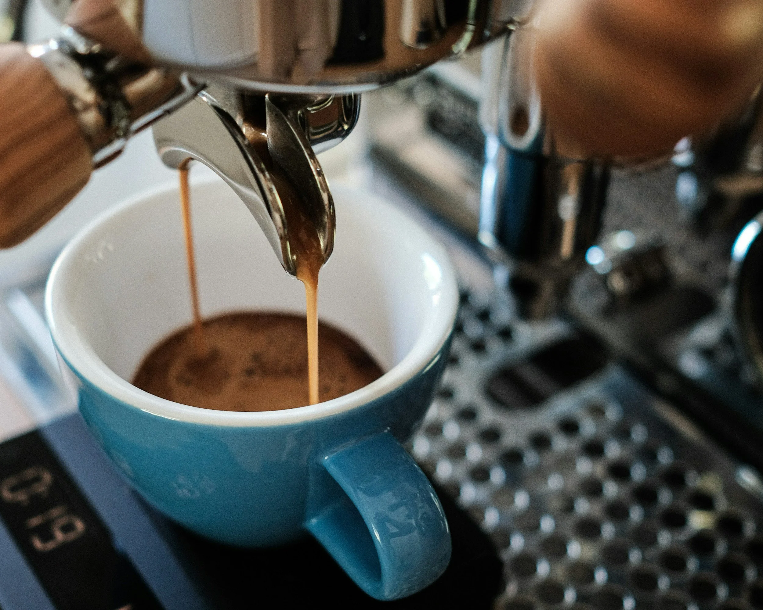 Espresso machine pouring espresso into a blue cup.