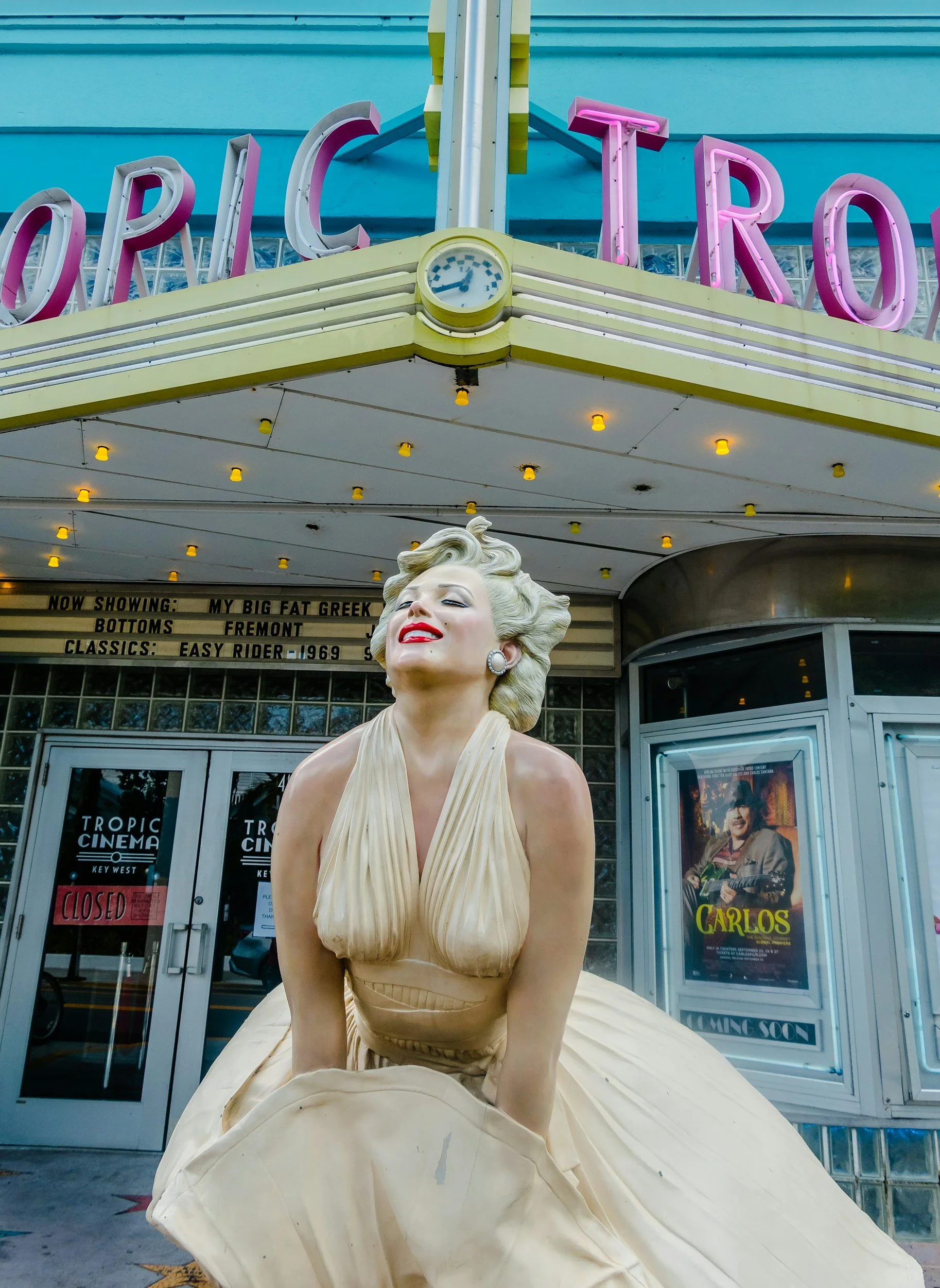Statue of Marilyn Monroe in front of Tropic Cinema, showing her with a classic pose, platinum blonde hair, red lipstick, and a beige gown.