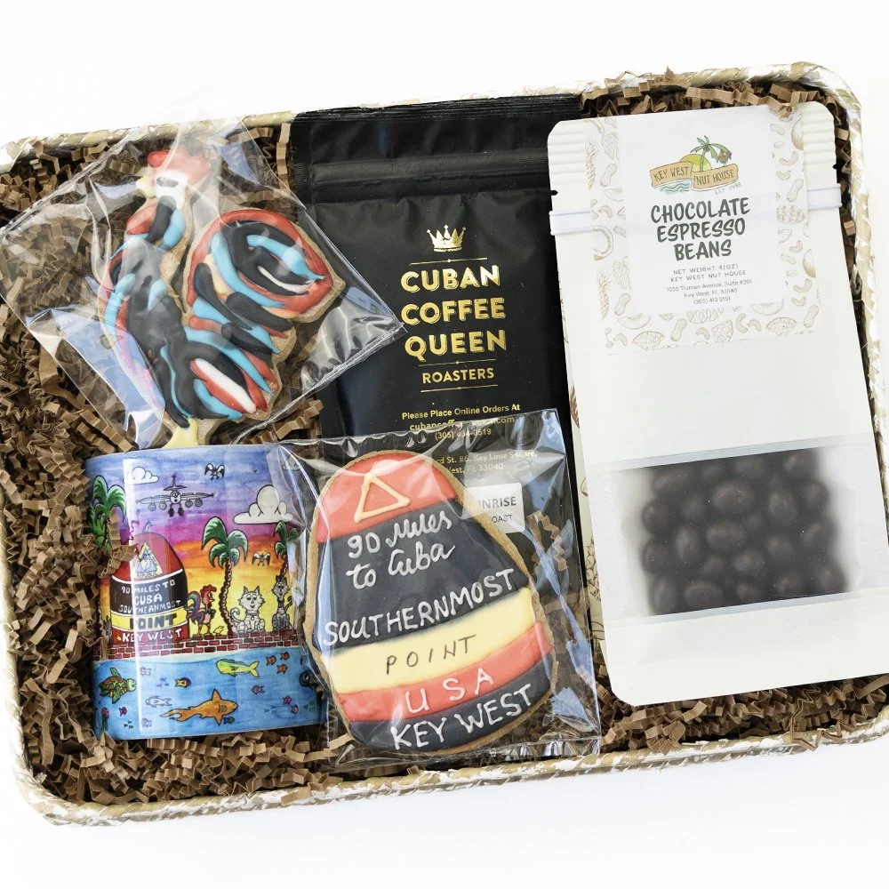 Gift box containing decorated cookies, a bag of Cuban coffee, a container of chocolate espresso beans, and an informational card about Key West, Florida.