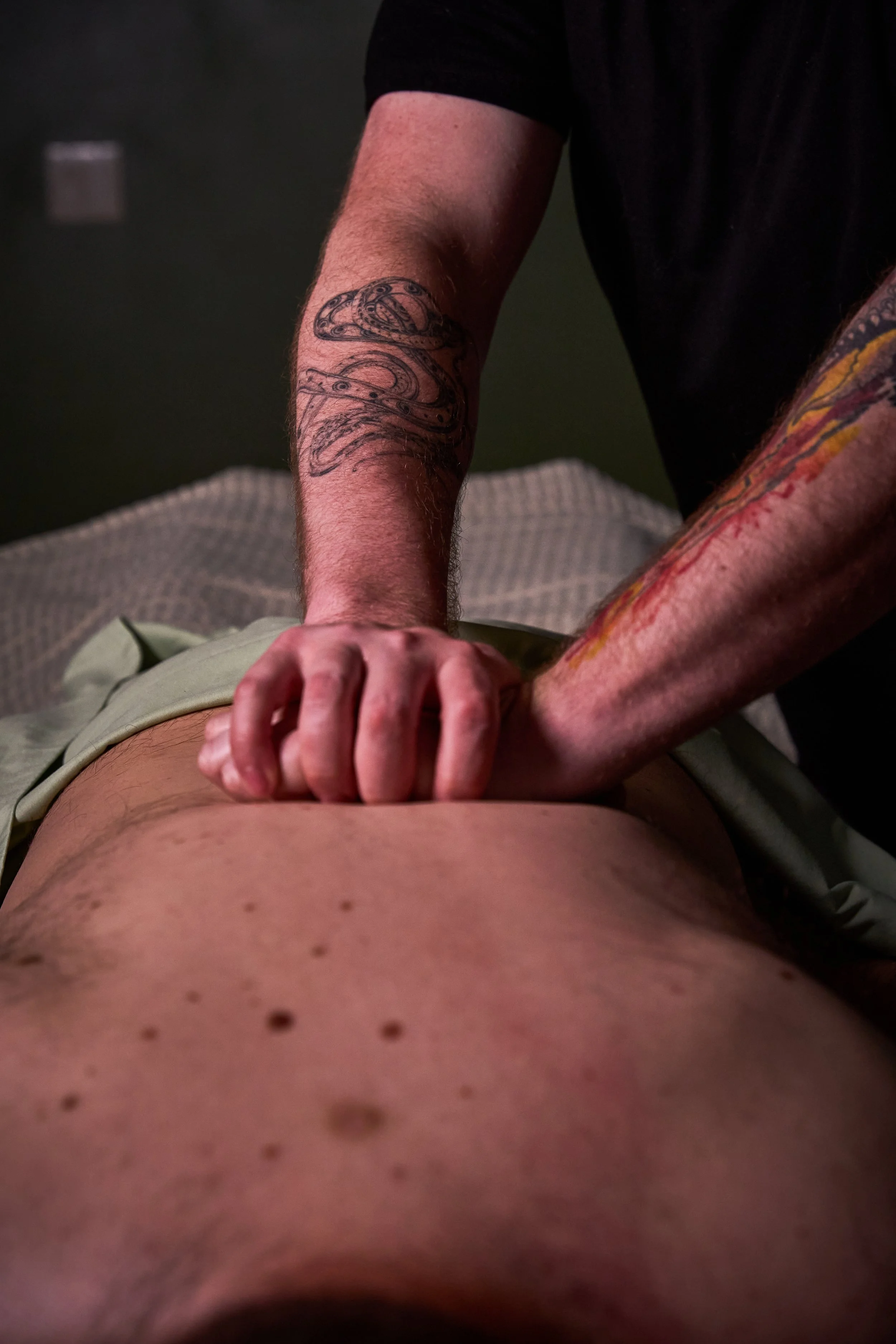 A person receiving a back massage, lying face down on a massage table.