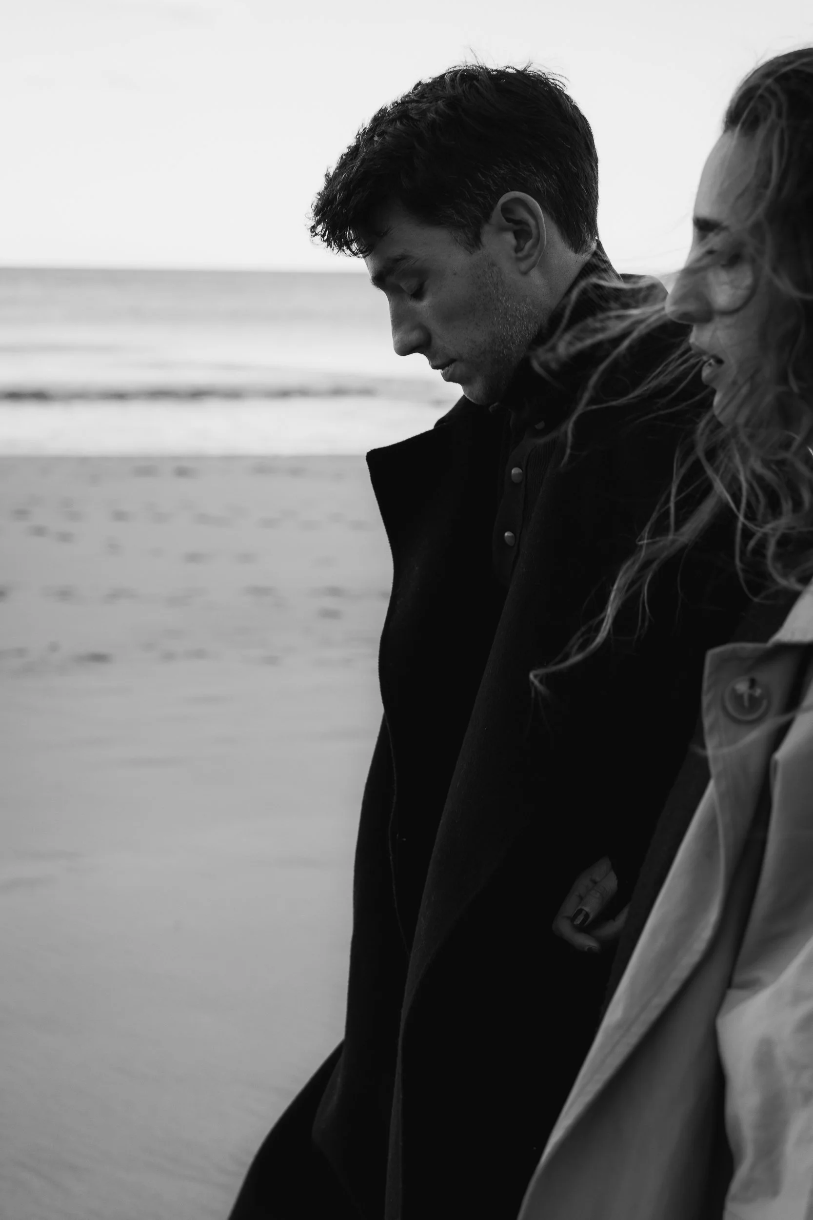 A man and woman stroll along the beach, enjoying the scenery, photographed in Sydney.