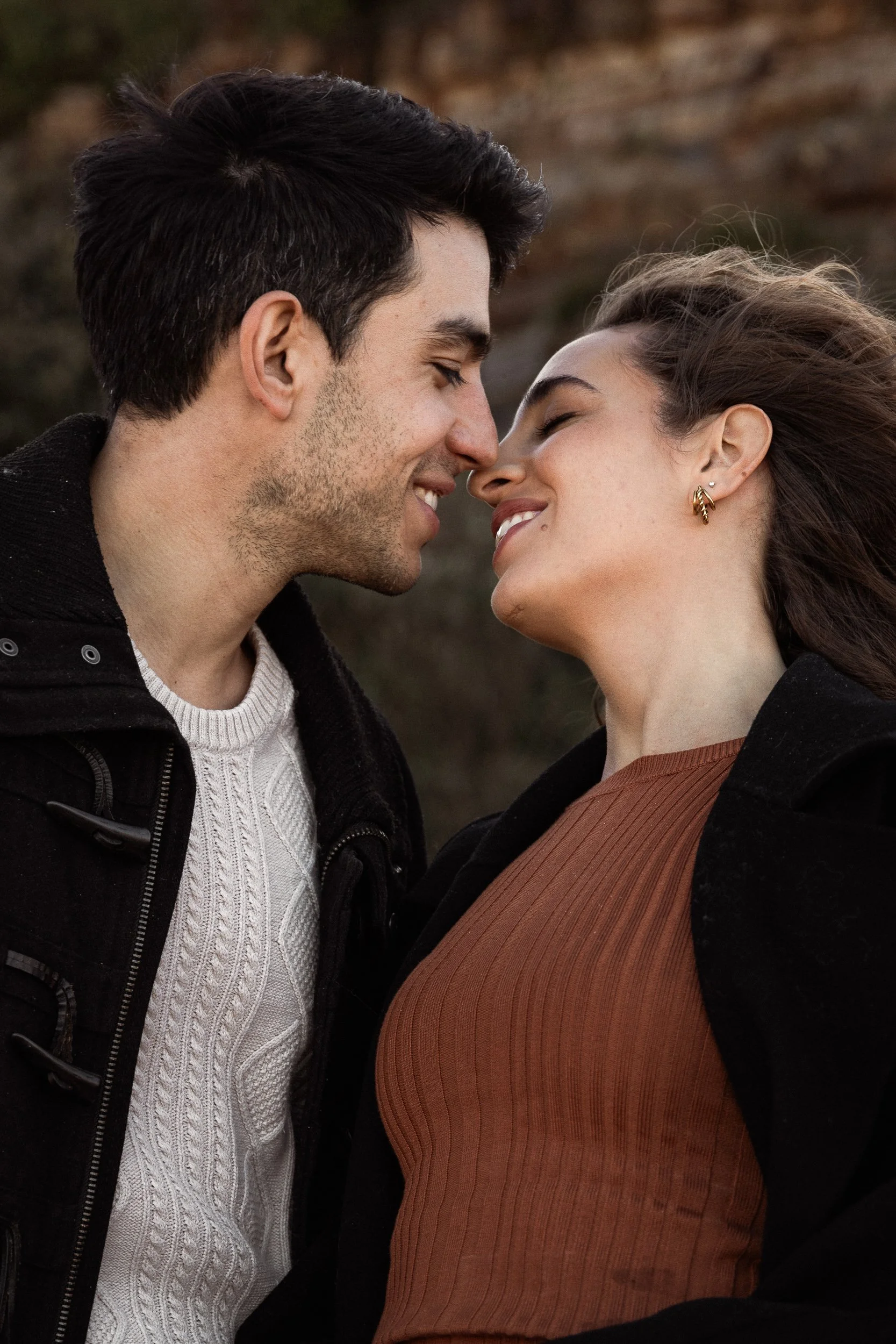 A smiling couple gazes at each other, capturing a joyful moment during a fun photoshoot in Sydney.