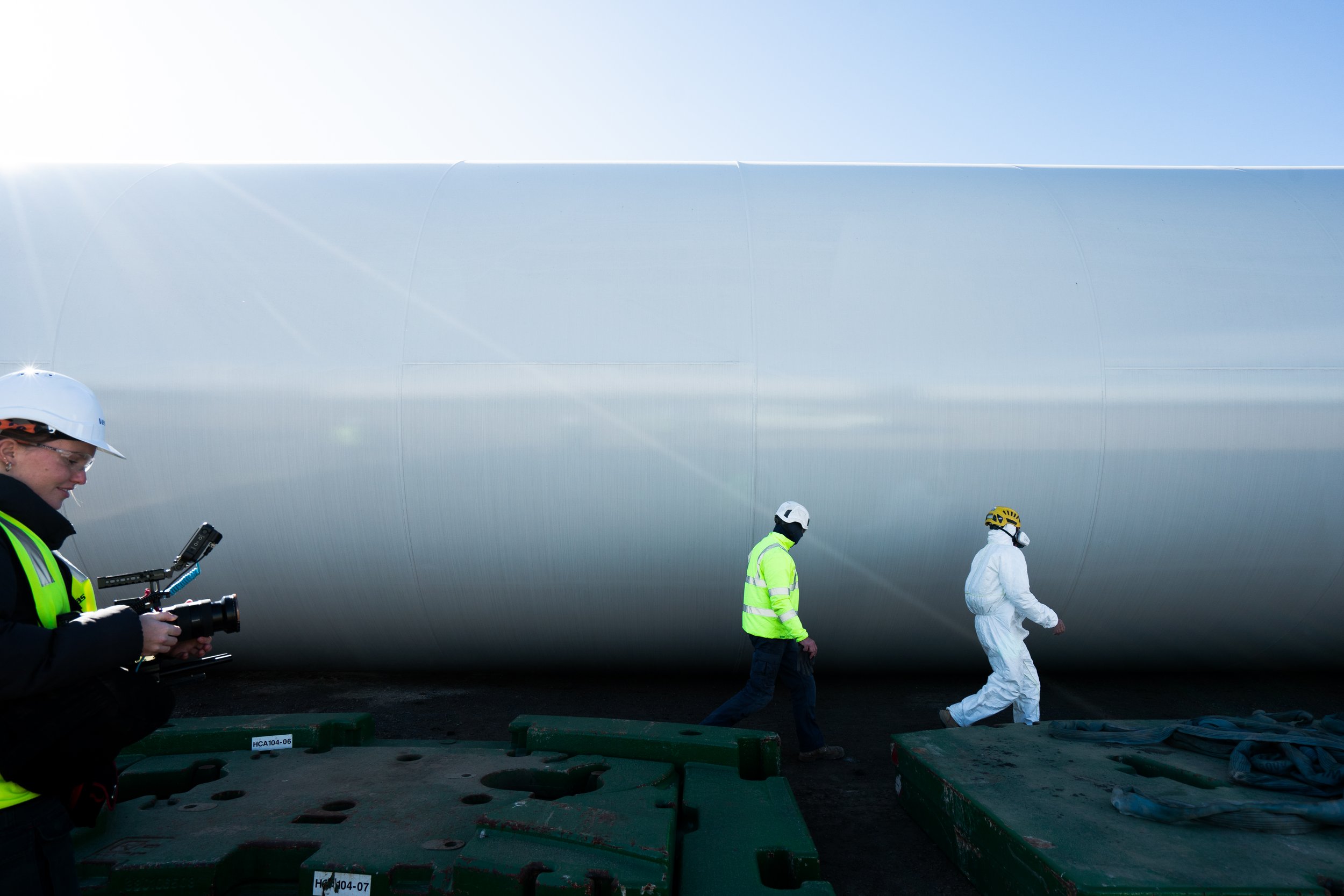 Workers in safety gear near large industrial pipe